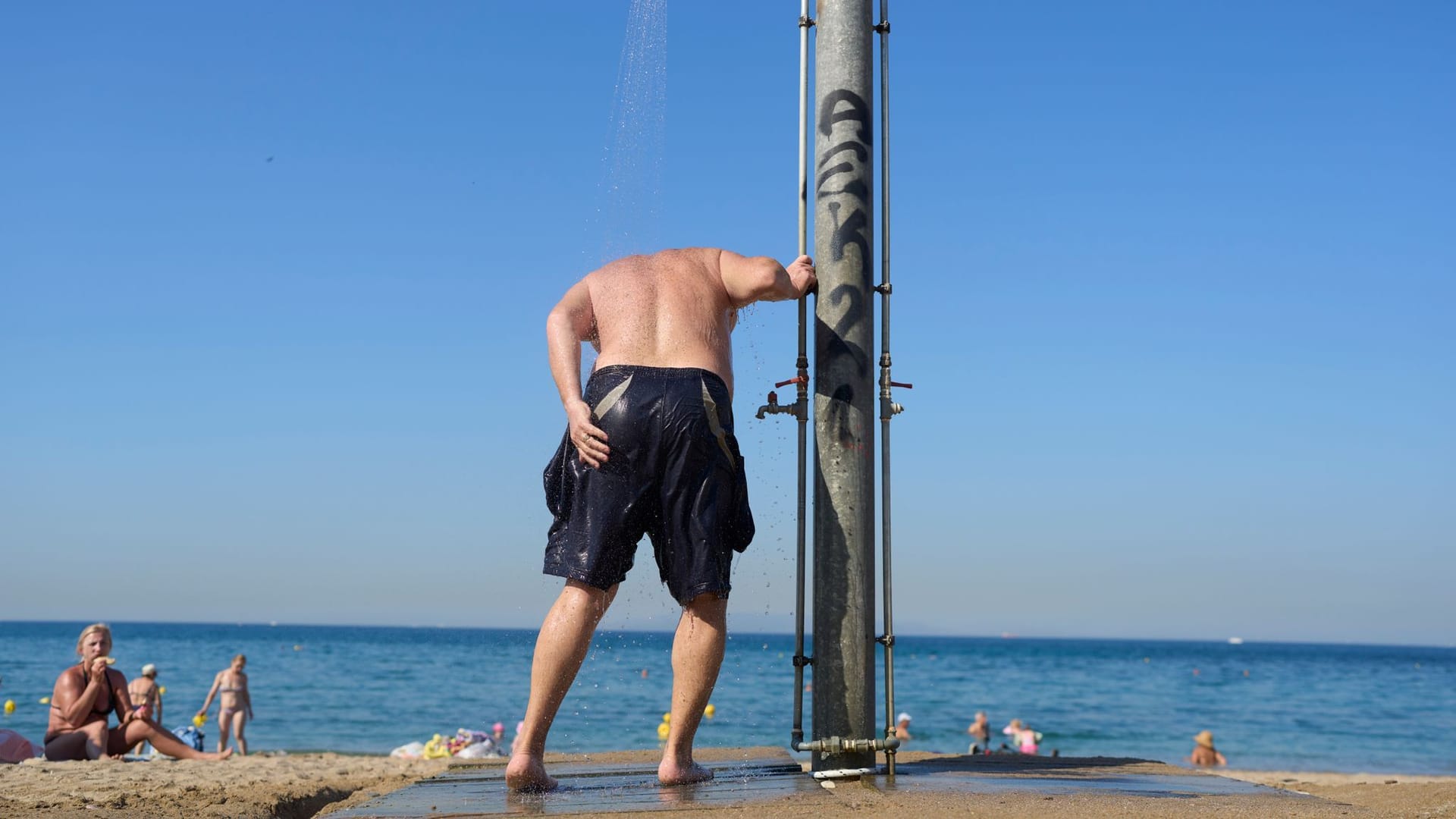 Ein Mann kühlt sich unter einer Dusche ab (Symbolbild): In der Balkanregion drohen Temperaturen von über 40 Grad.