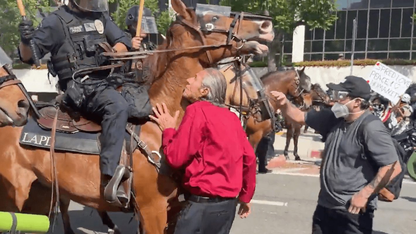 Berittene Polizisten stürmen auf Demonstranten in Los Angeles zu.