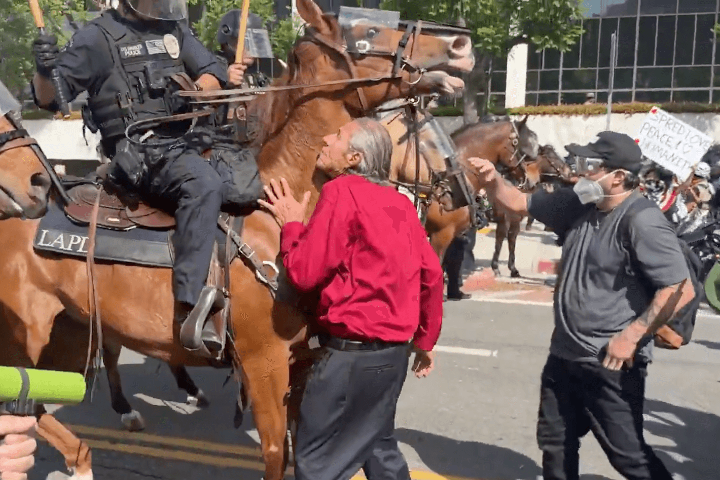 Berittene Polizisten stürmen auf Demonstranten in Los Angeles zu.