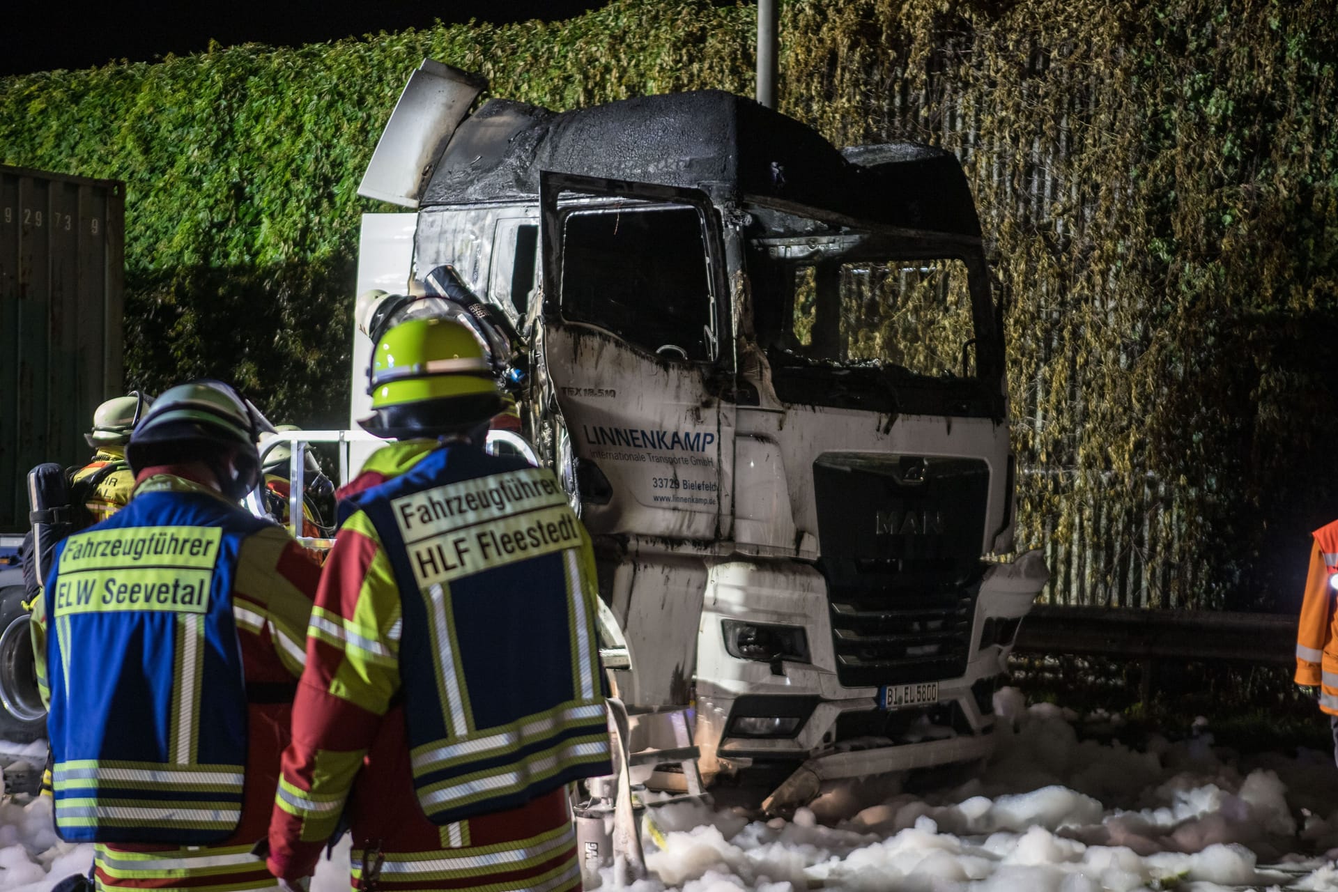 Rettungskräfte vor einem ausgebrannten Lkw-Wrack: Der Fahrer konnte sich laut ersten Informationen in letzter Sekunde aus dem Fahrzeug retten.