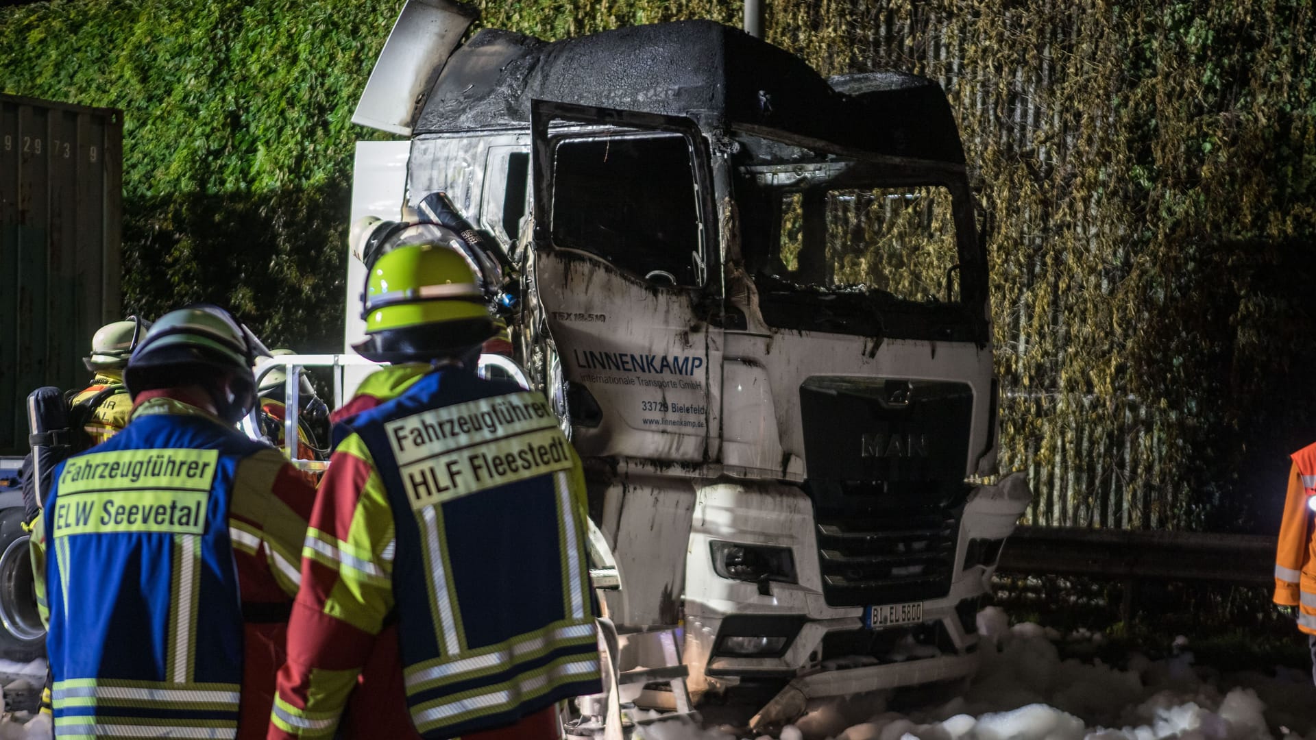 Rettungskräfte vor einem ausgebrannten Lkw-Wrack: Der Fahrer konnte sich laut ersten Informationen in letzter Sekunde aus dem Fahrzeug retten.