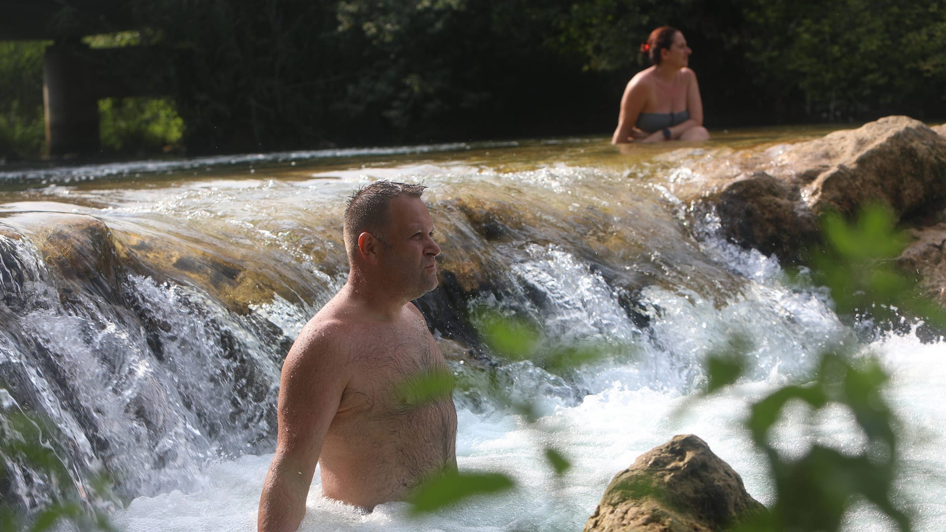 Abkühlung und Massage: Ein Paar erfrischt sich im Fluss Mrežnica in Kroatien.
