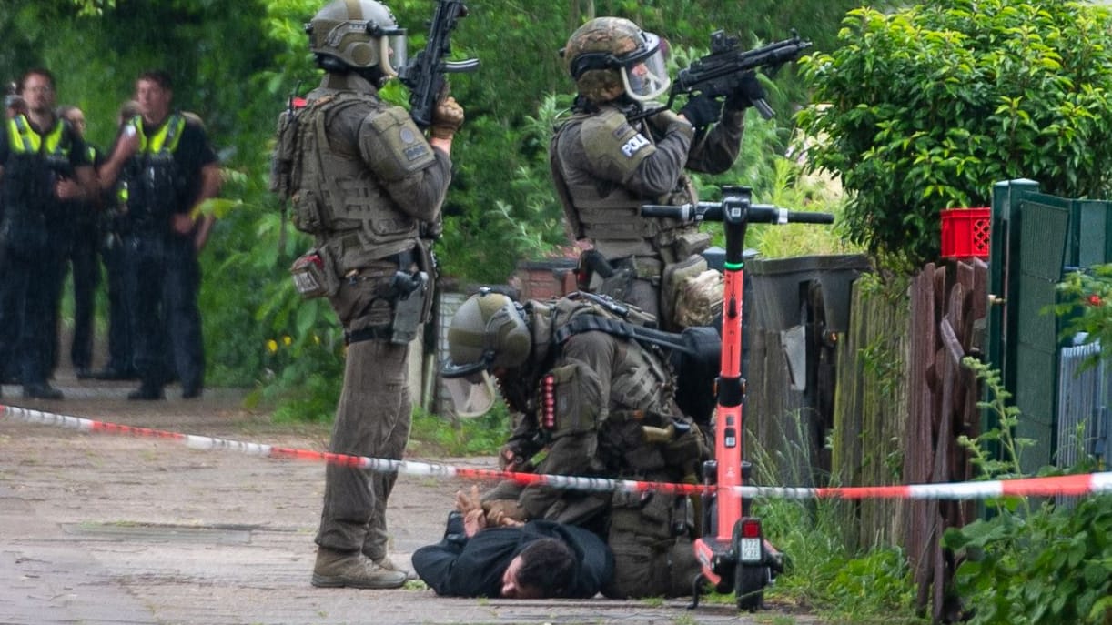SEK-Beamte nehmen einen Mann fest: Nach der Festnahme durchsuchten Sondereinheiten das Gebäude.