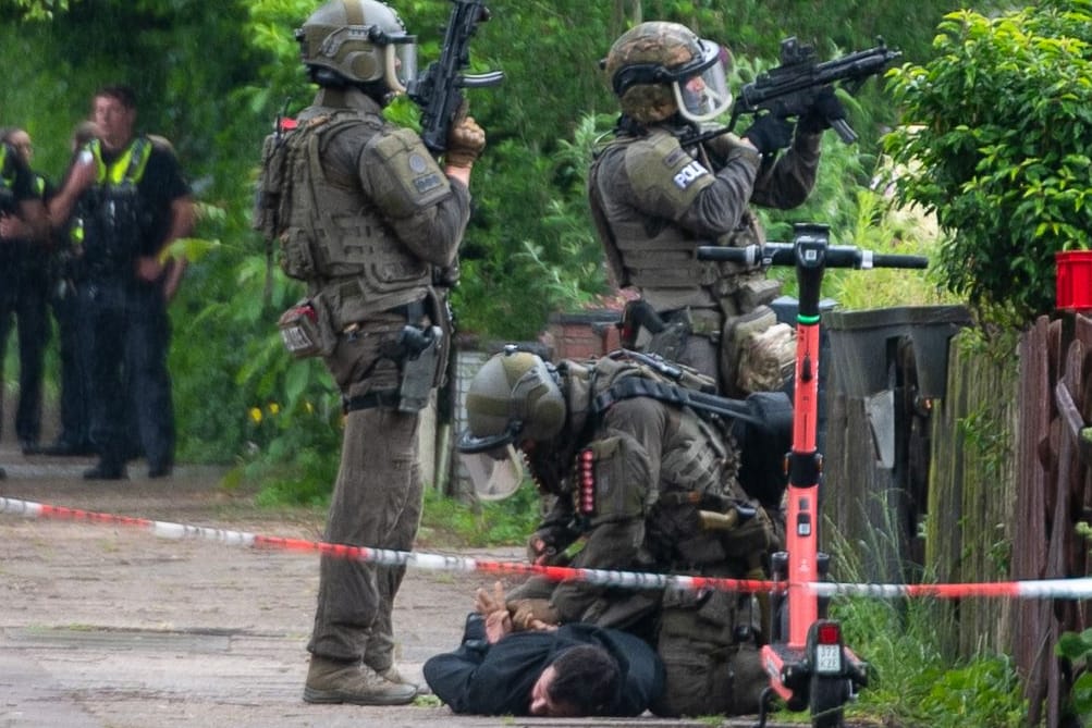 SEK-Beamte nehmen einen Mann fest: Nach der Festnahme durchsuchten Sondereinheiten das Gebäude.