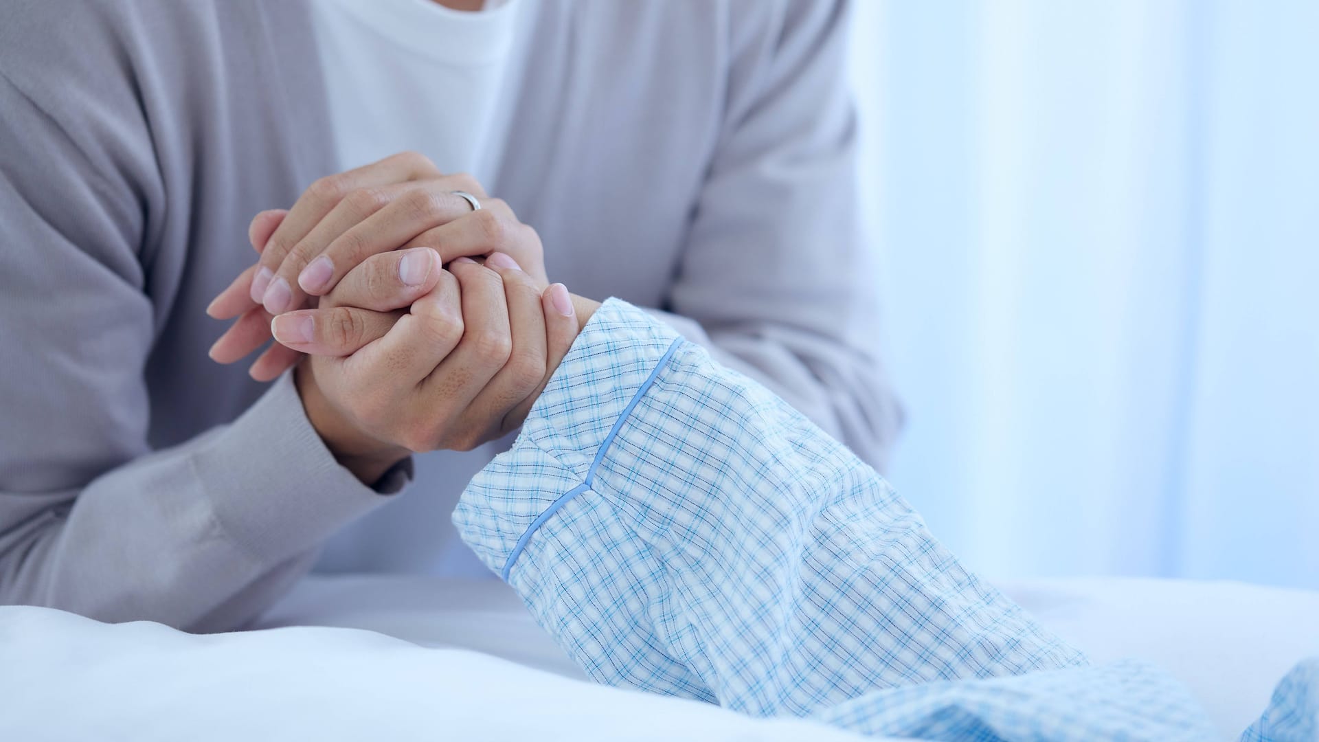 Eine Frau hält die Hand eines älteren Mannes (Symbolbild): In Frankreich hat eine 33-Jährige ihren Großvater umgebracht.