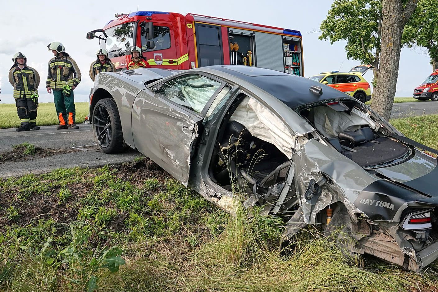 Rettungskräfte stehen an einem Unfallwrack: Auf der B173 sind am Pfingstsonntag zwei Autos kollidiert, acht Menschen wurden verletzt.