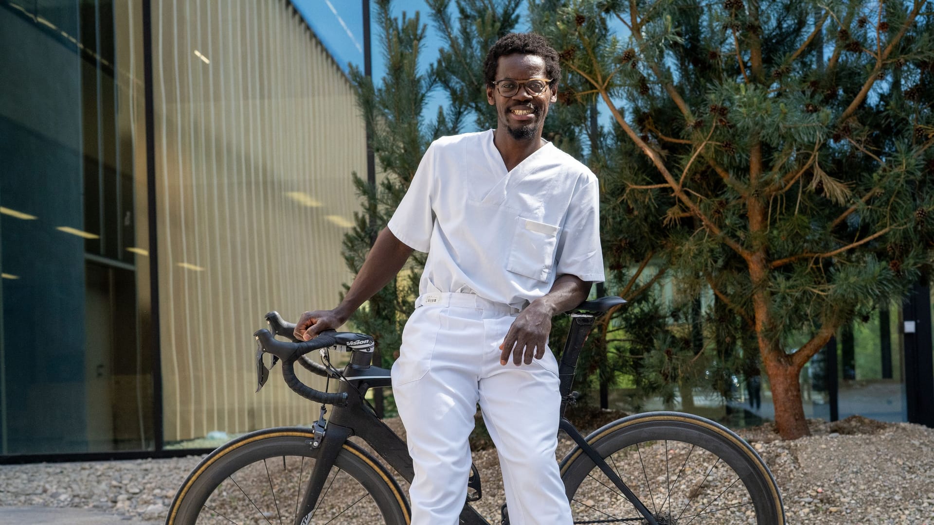 Emmanuel Adjei mit seinem Fahrrad auf dem Campus für Präventive Sportmedizin der TU München (TUM) am Olympiapark.