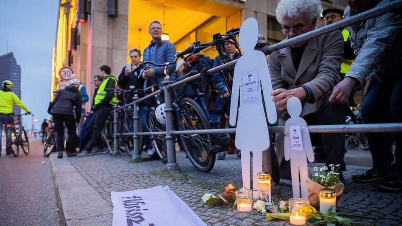 Weiße Silhouetten einer Frau und eines Kindes stehen bei einer Mahnwache an der Leipziger Straße: Der Prozess soll um 9 Uhr beginnen.