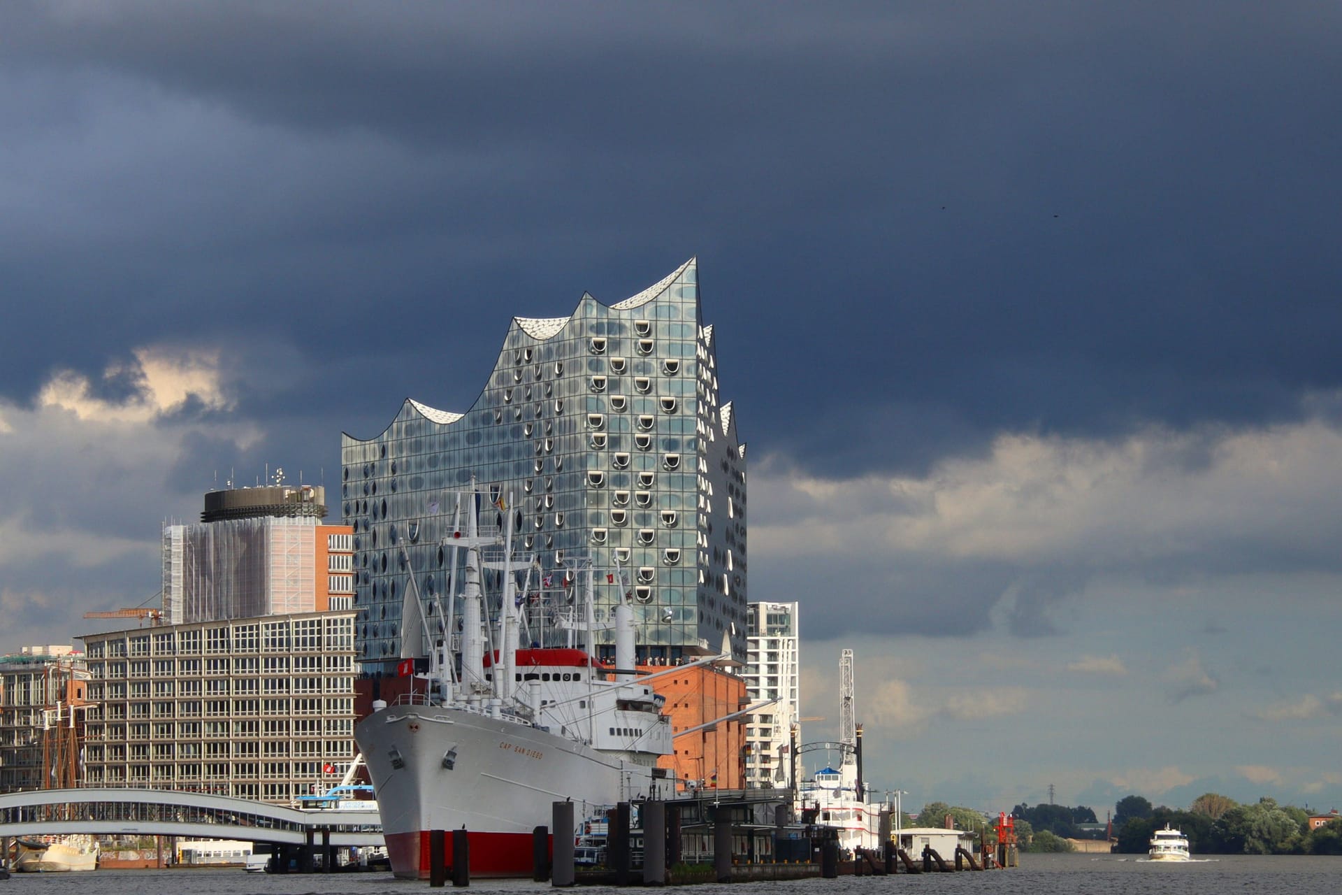 Dunkle Wolken über der Elbphilharmonie und das Museumsschiff Cap San Diego: Das Wetter im Norden bleibt wechselhaft.