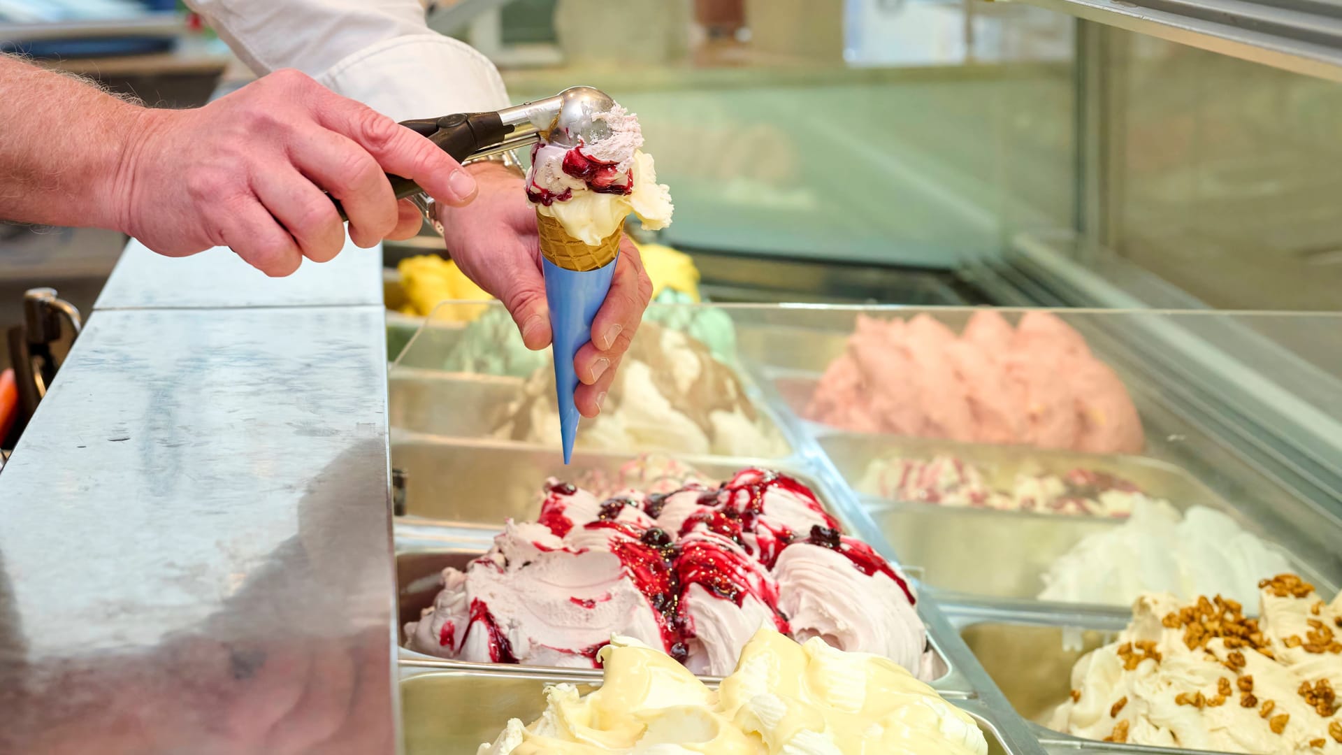 Ein Eisverkäufer füllt eine Eiswaffel (Symbolbild): Eiscreme ist in den vergangenen Jahren teurer geworden. Ein Eisverkäufer füllt eine Eiswaffel (Symbolbild): Eiscreme ist in den vergangenen Jahren teurer geworden.
