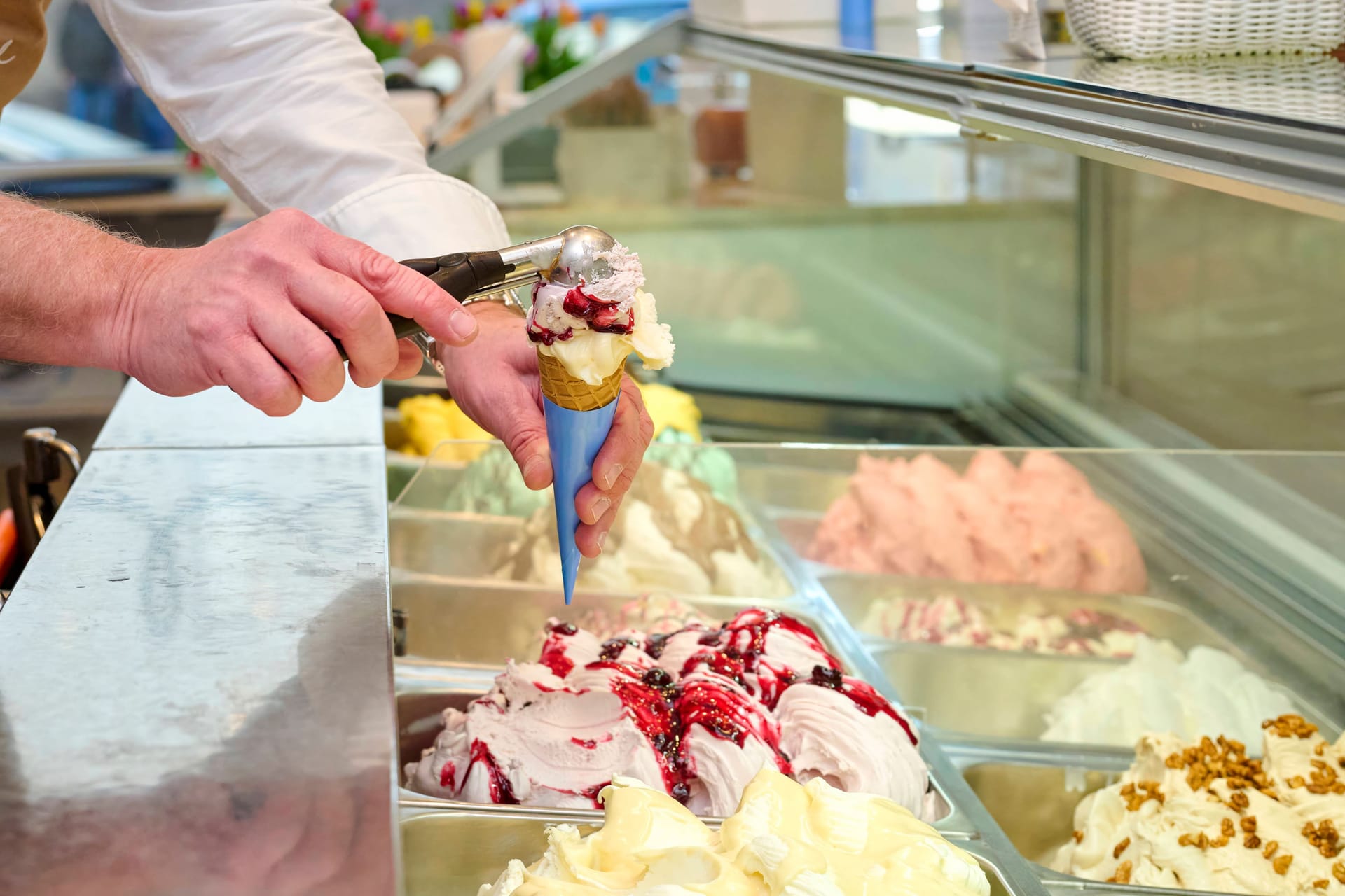 Ein Eisverkäufer füllt eine Eiswaffel (Symbolbild): Eiscreme ist in den vergangenen Jahren teurer geworden.