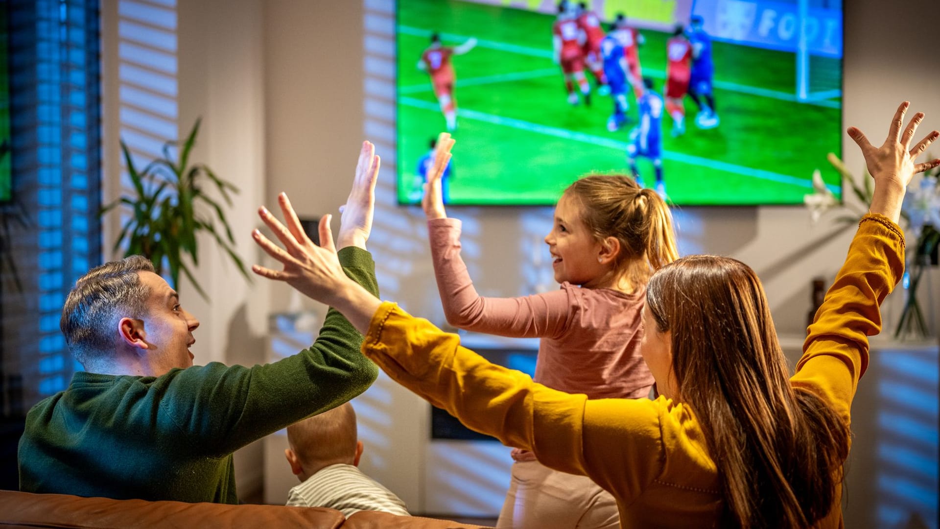 Familie schaut Live-Fußballspiel im TV