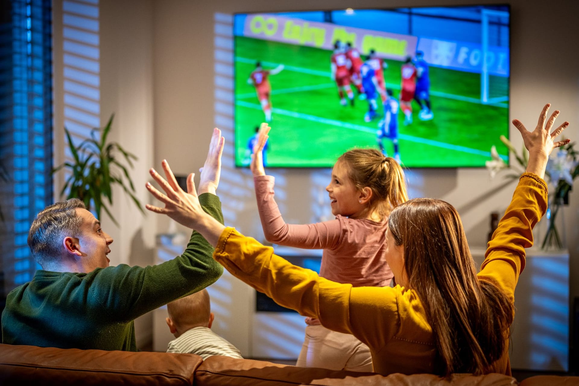 Familie schaut Live-Fußballspiel im TV