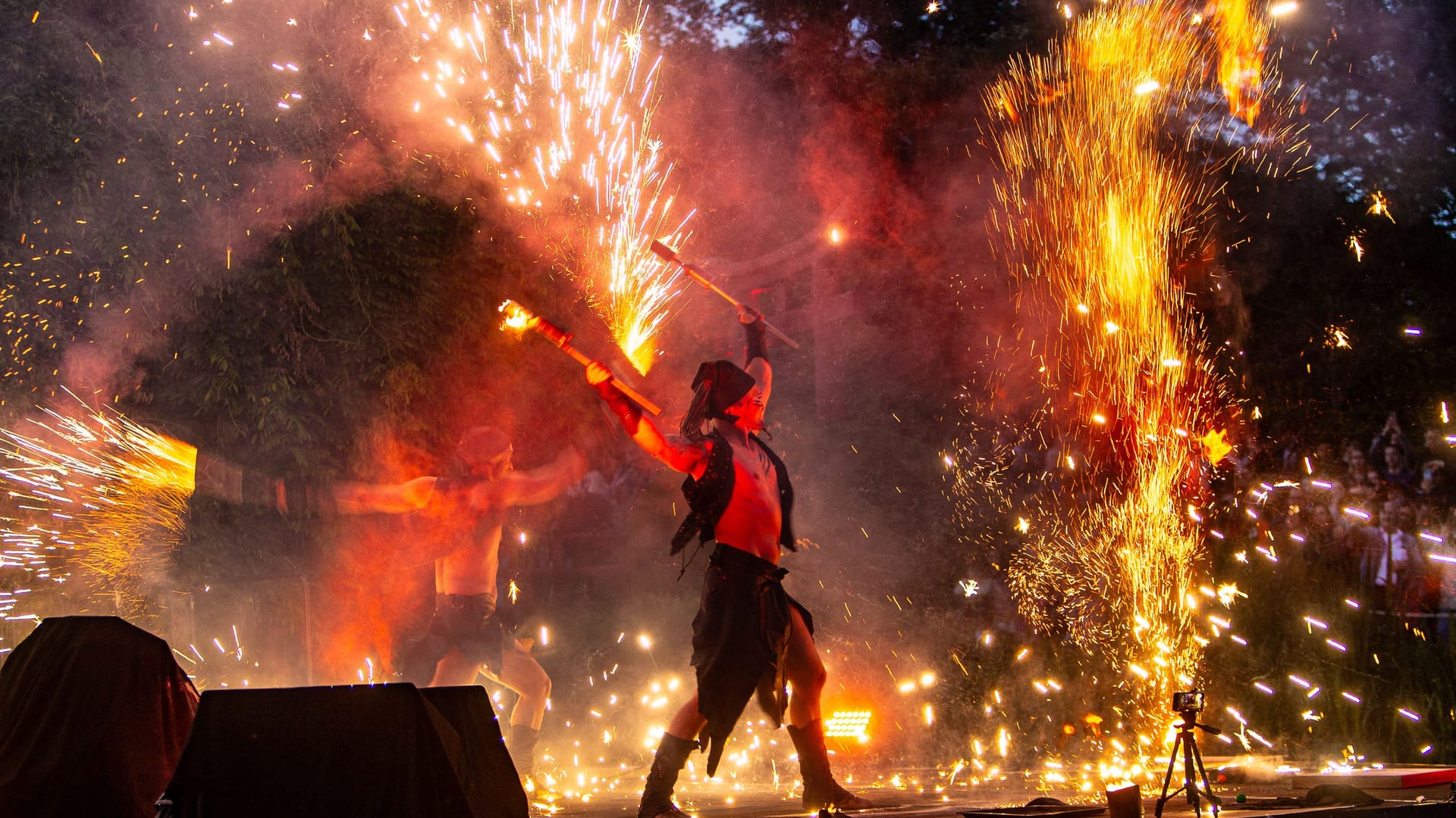 Funkenregen bei den Dschungel-Nächten: Mit Fackeln, Feuerwirbeln und Pyroeffekten heizen Künstler dem Publikum ein.