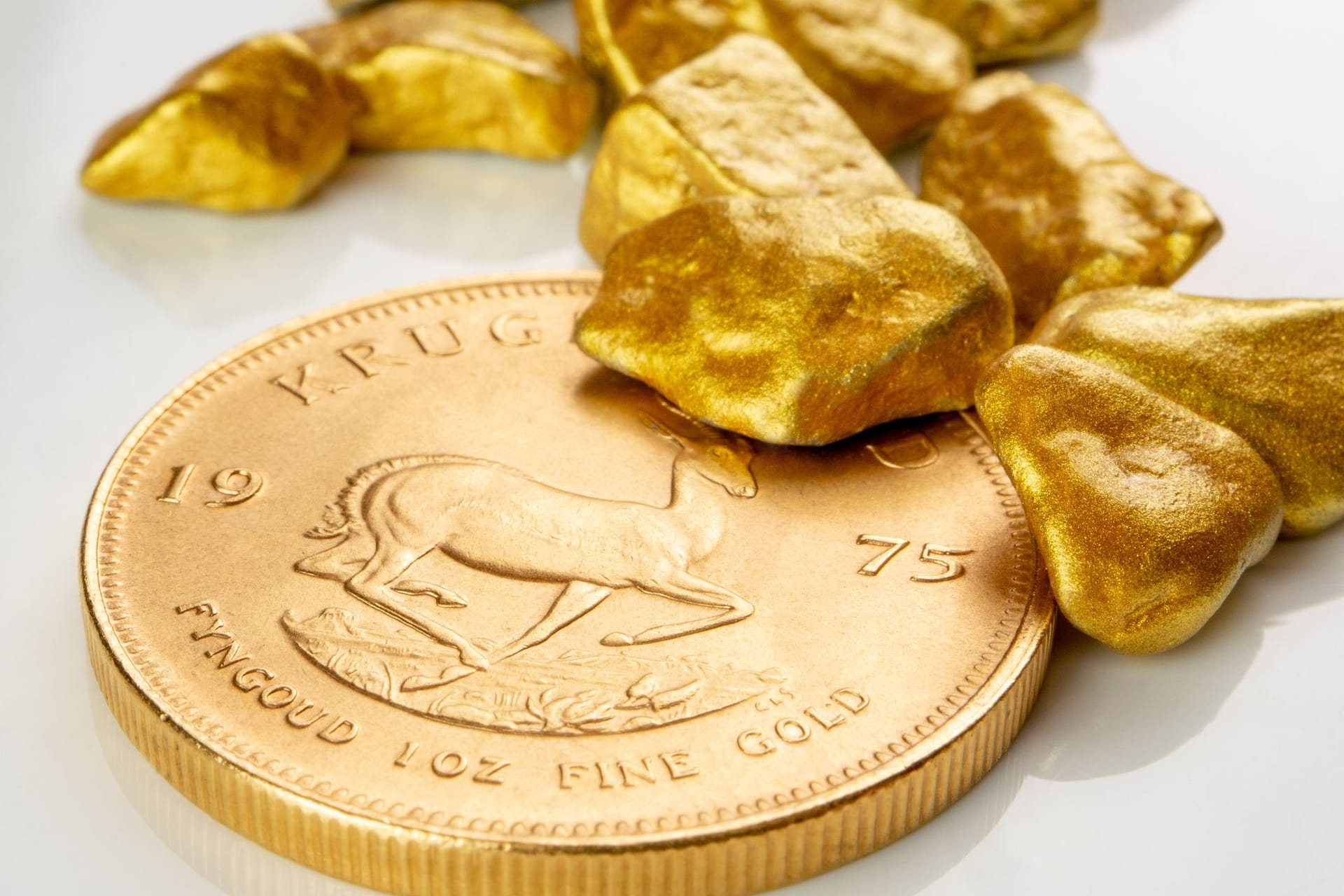 Goldene südafrikanische Krügerrand 1 Unze Münze auf einem Haufen von goldenen Nuggets Goldene südafrikanische Krügerrand 1 Unze Münze auf einem Haufen von goldenen Nuggets