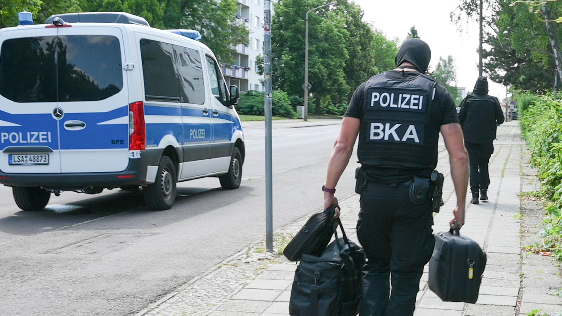 Polizeieinsatz in Halle: BKA-Beamte kommen mit Kisten und Taschen aus einem Gebäude. Polizeieinsatz in Halle: BKA-Beamte kommen mit Kisten und Taschen aus einem Gebäude.