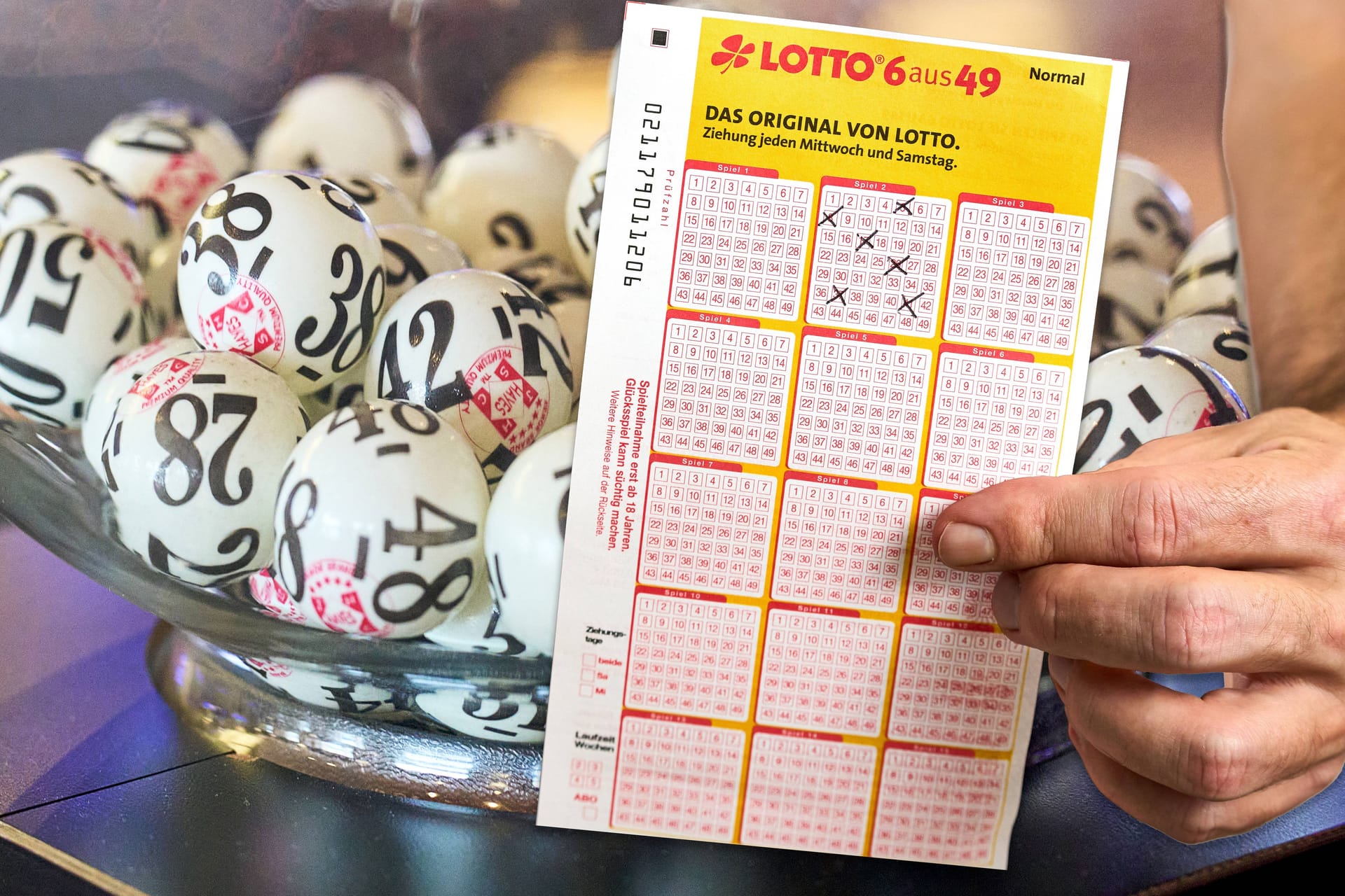 Lotto-Spielschein vor den Loskugeln (Symbolfoto): Der Gewinner aus dem Hochtaunuskreis hat sich seit über zwei Monaten nicht bei der Lotterie gemeldet.