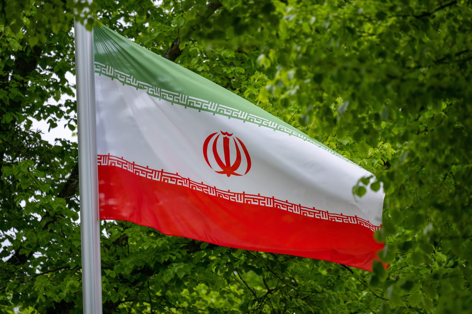 Die Flagge der Islamischen Republik Iran weht vor der Botschaft in Berlin (Archivbild): Ein pro-iranischer Protestzug für Sonntag wurde kurzfristig abgemeldet.
