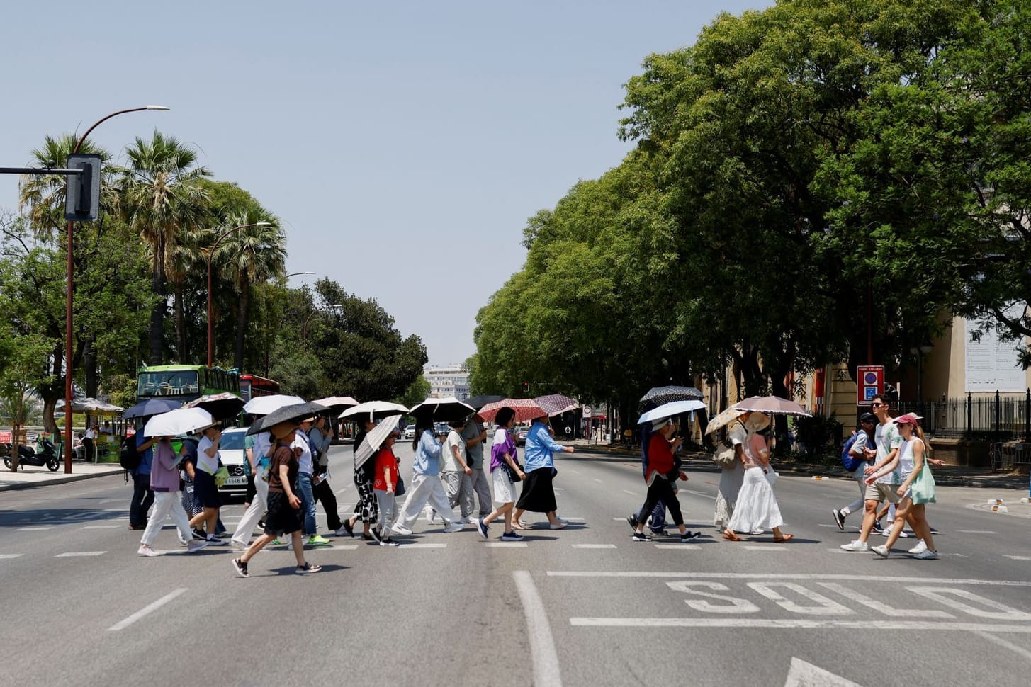 Touristen schützen sich mit Schirmen vor der heißen Sonne in Sevilla: An mehreren Orten erreichten die Temperaturen Werte von über 40 Grad.