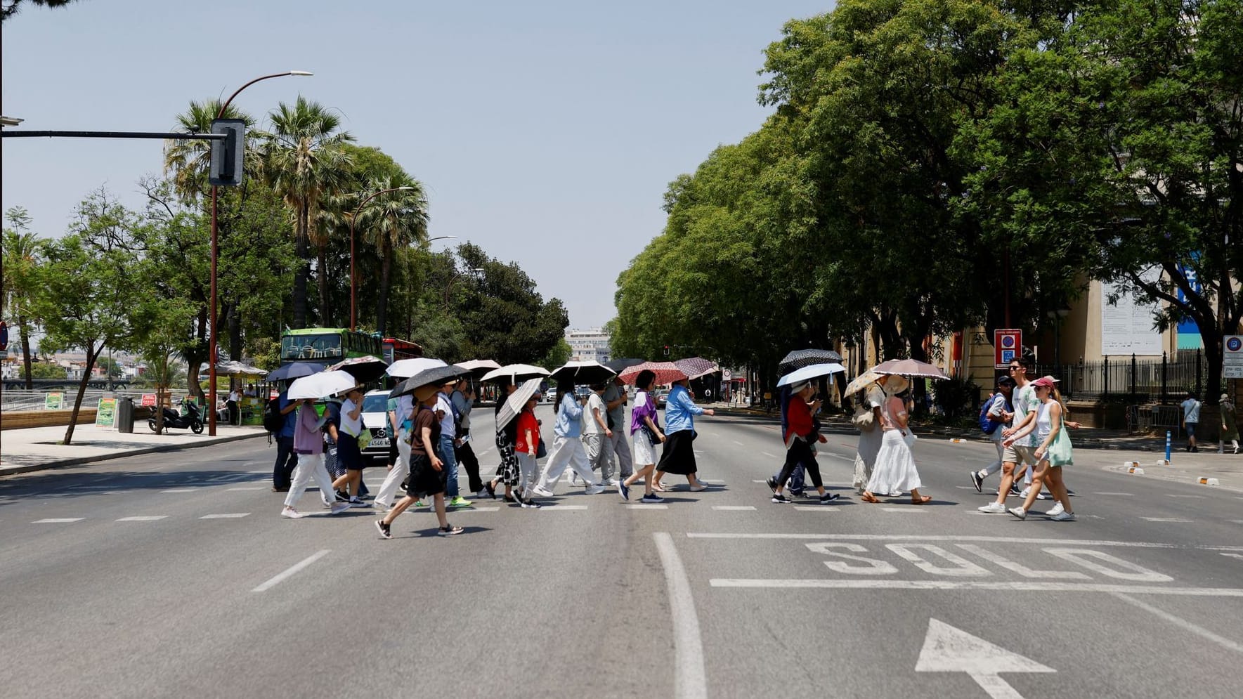 Touristen schützen sich mit Schirmen vor der heißen Sonne in Sevilla: An mehreren Orten erreichten die Temperaturen Werte von über 40 Grad.