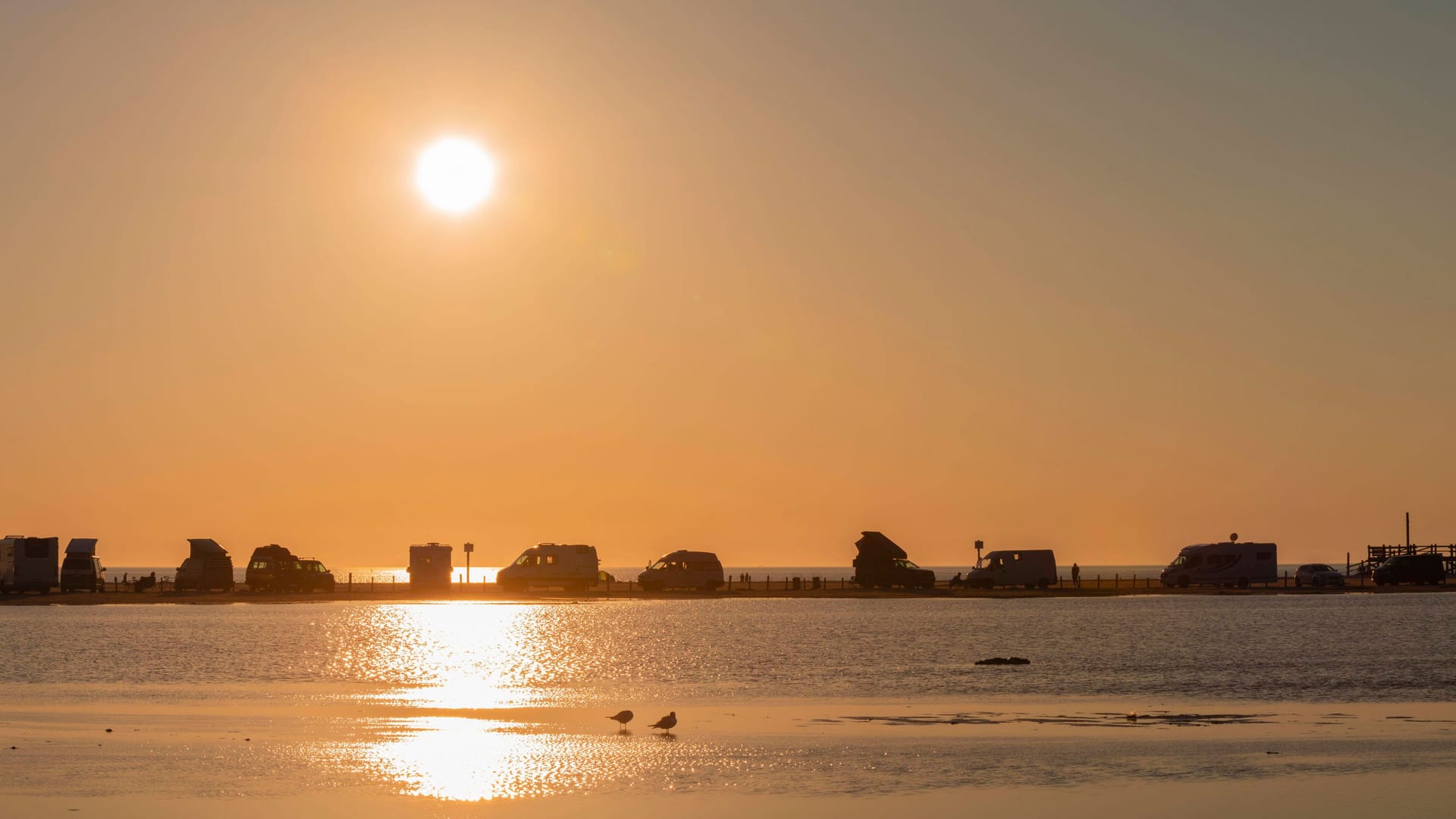 Camper am Strand St. Peter Ording im Sonnenuntergang (Archivbild): An der Nordsee gibt es einige Campingplätze, an denen Camper ganz nah am Meer schlafen können.