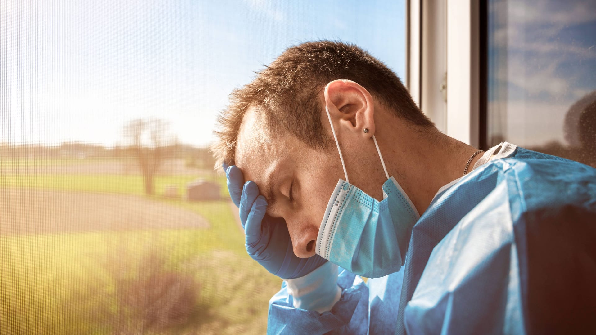 Pflegekraft erschöpft am Fenster (Symbolbild): Für die Pflegeeinrichtungen und Kliniken wird die Sommerhitze zur Herausforderung. Pflegekraft erschöpft am Fenster (Symbolbild): Für die Pflegeeinrichtungen und Kliniken wird die Sommerhitze zur Herausforderung.