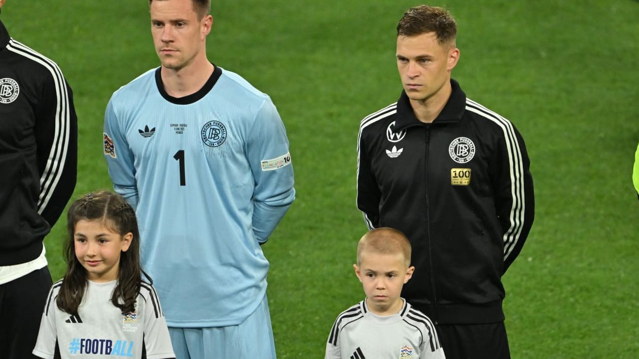 Mit "100"-Aufnäher auf der Trainingsjacke: Joshua Kimmich und einer seiner Söhne vor Anpfiff der Partie gegen Portugal.