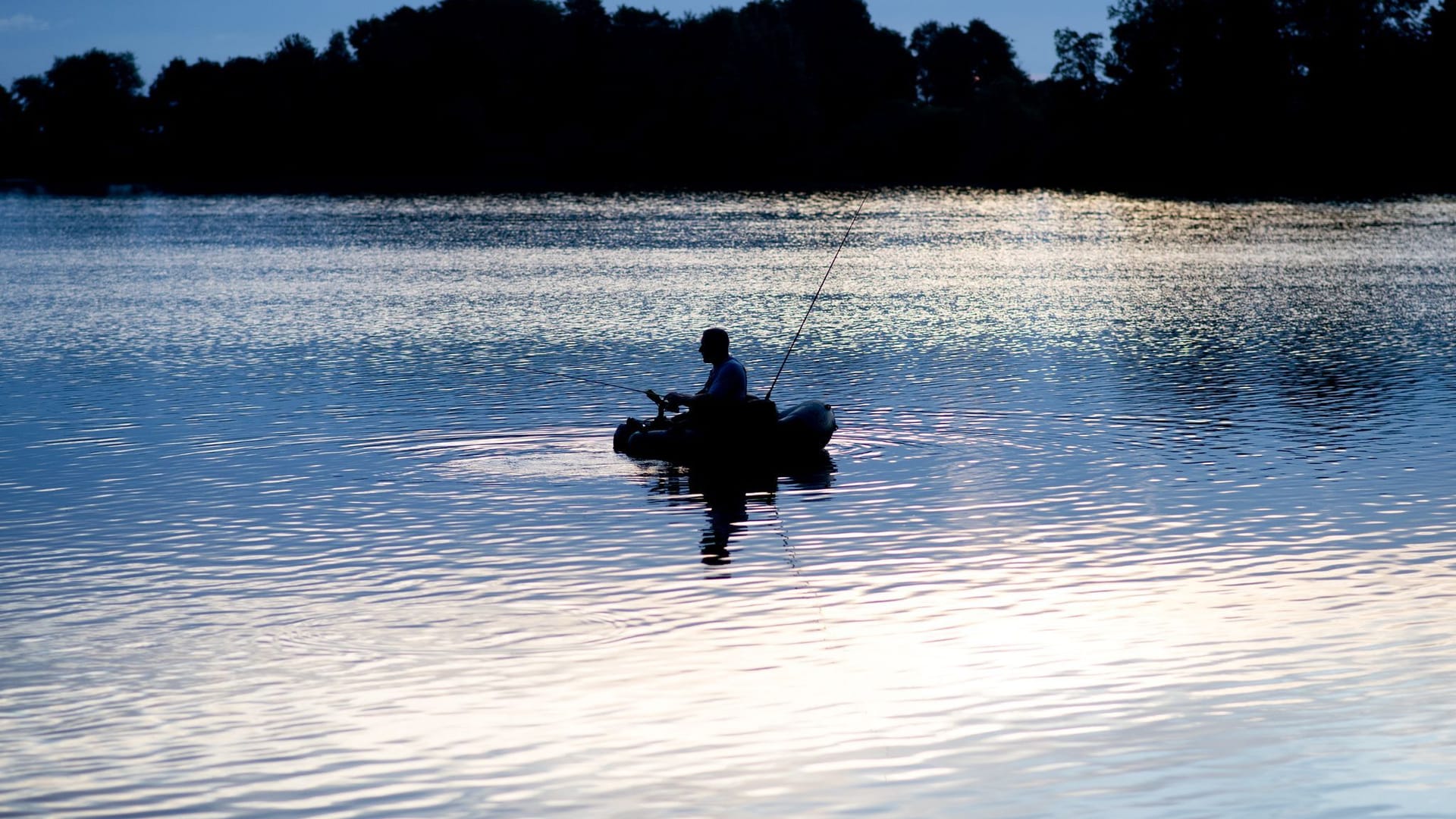 Ein Angler kurz nach Sonnenaufgang