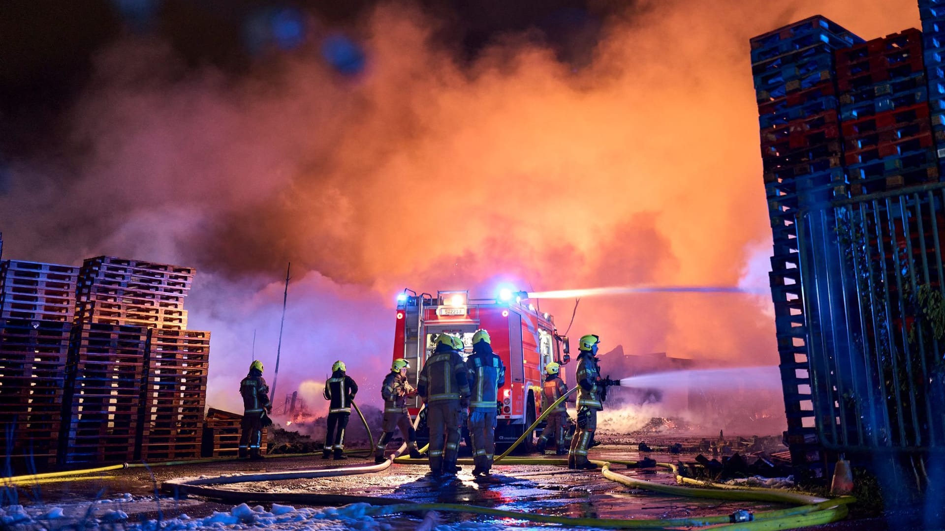 Einsatzkräfte der Feuerwehr löschen einen Brand auf einem Firmengelände in Berlin-Marzahn.