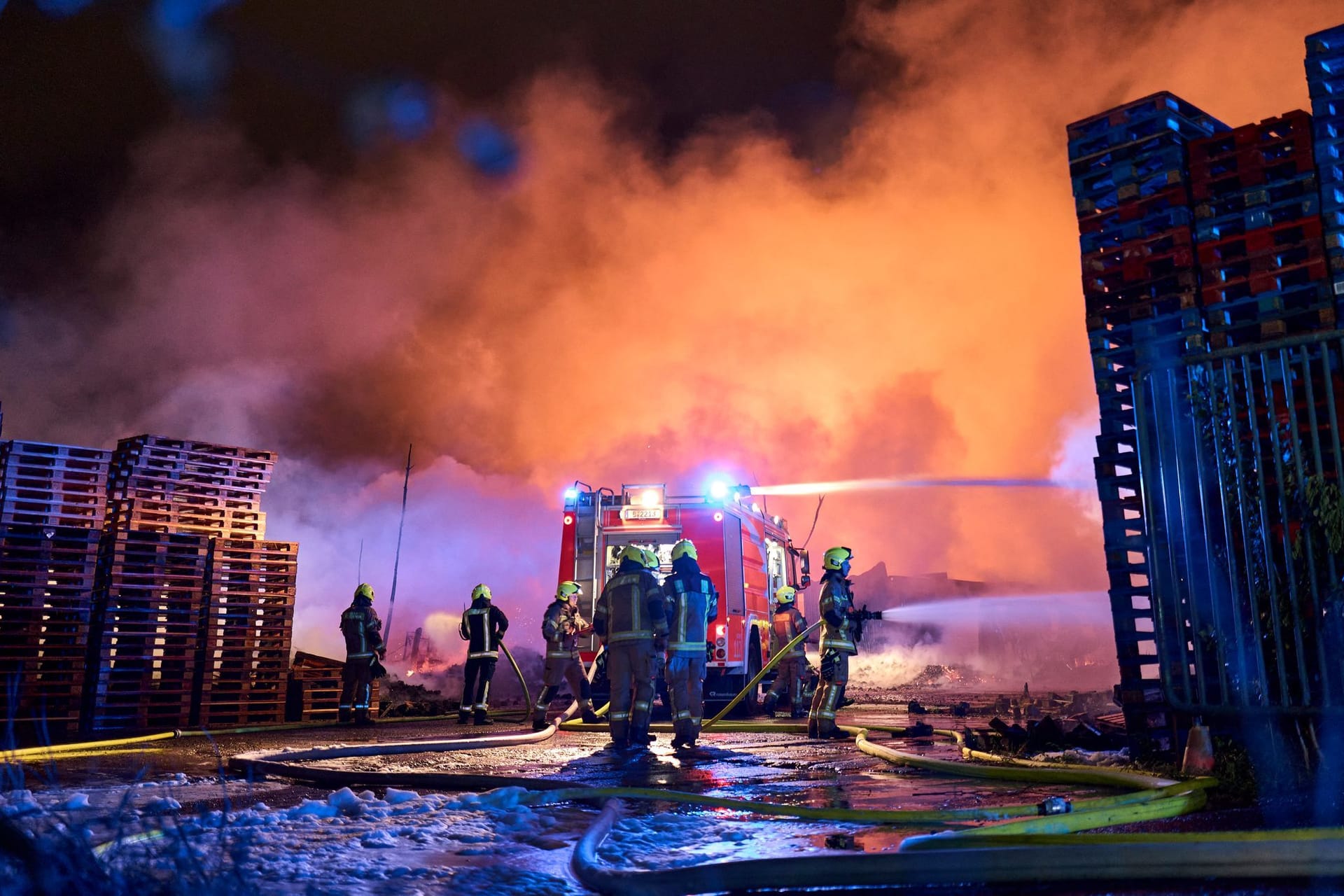 Einsatzkräfte der Feuerwehr löschen einen Brand auf einem Firmengelände in Berlin-Marzahn.