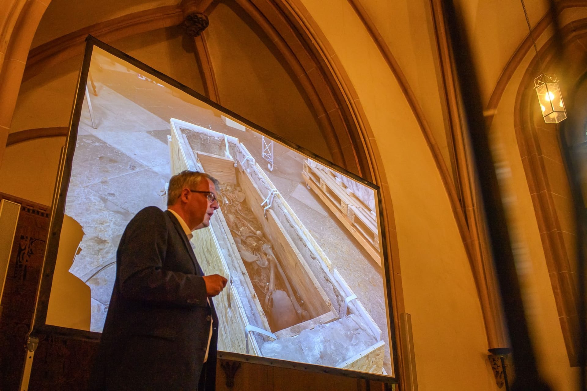 Donat Wehner (l) vom Landesamt für Denkmalpflege und Archäologie Sachsen-Anhalt spricht über den Sarg, in dem vermutlich Otto I. liegt.