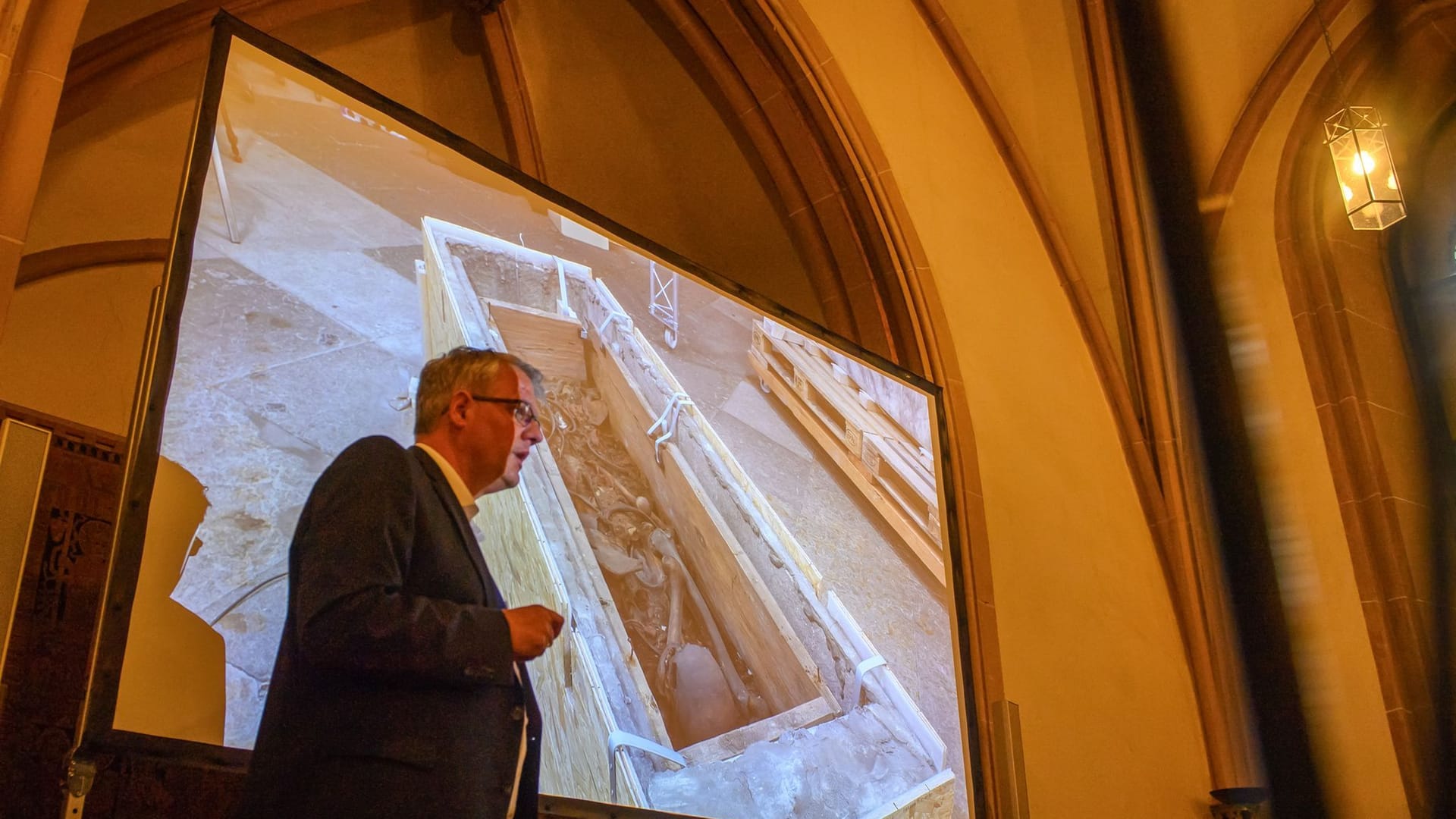 Donat Wehner (l) vom Landesamt für Denkmalpflege und Archäologie Sachsen-Anhalt spricht über den Sarg, in dem vermutlich Otto I. liegt.