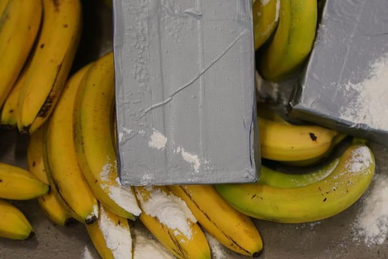 Silber-graue Pakete und weißes Pulver, das Kokain darstellen soll, liegt neben Bananen und Bananenkisten während der Vorstellung der Awareness-Kampagne für Hafenbeschäftigte im Kampf gegen internationale Drogenkriminalität. Die Sicherheitsbehörden haben die neue Awareness-Kampagne am Montag vorgestellt. (zu dpa: «Polizei findet Drogen in Bananenkisten in Supermärkten»)