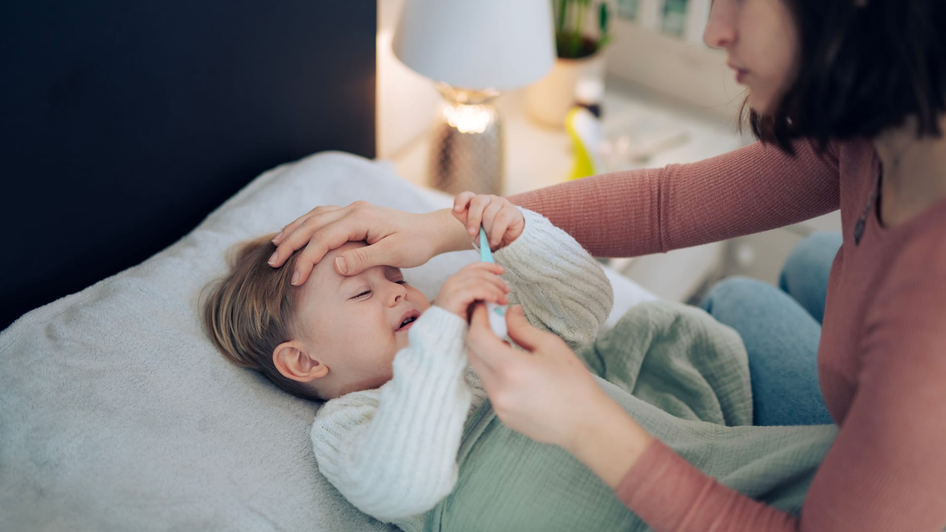 Besorgte Mutter prüft die Temperatur ihres Kindes: Bei einer Hib-Infektion kann es zu Fieber kommen. Besorgte Mutter prüft die Temperatur ihres Kindes: Bei einer Hib-Infektion kann es zu Fieber kommen.
