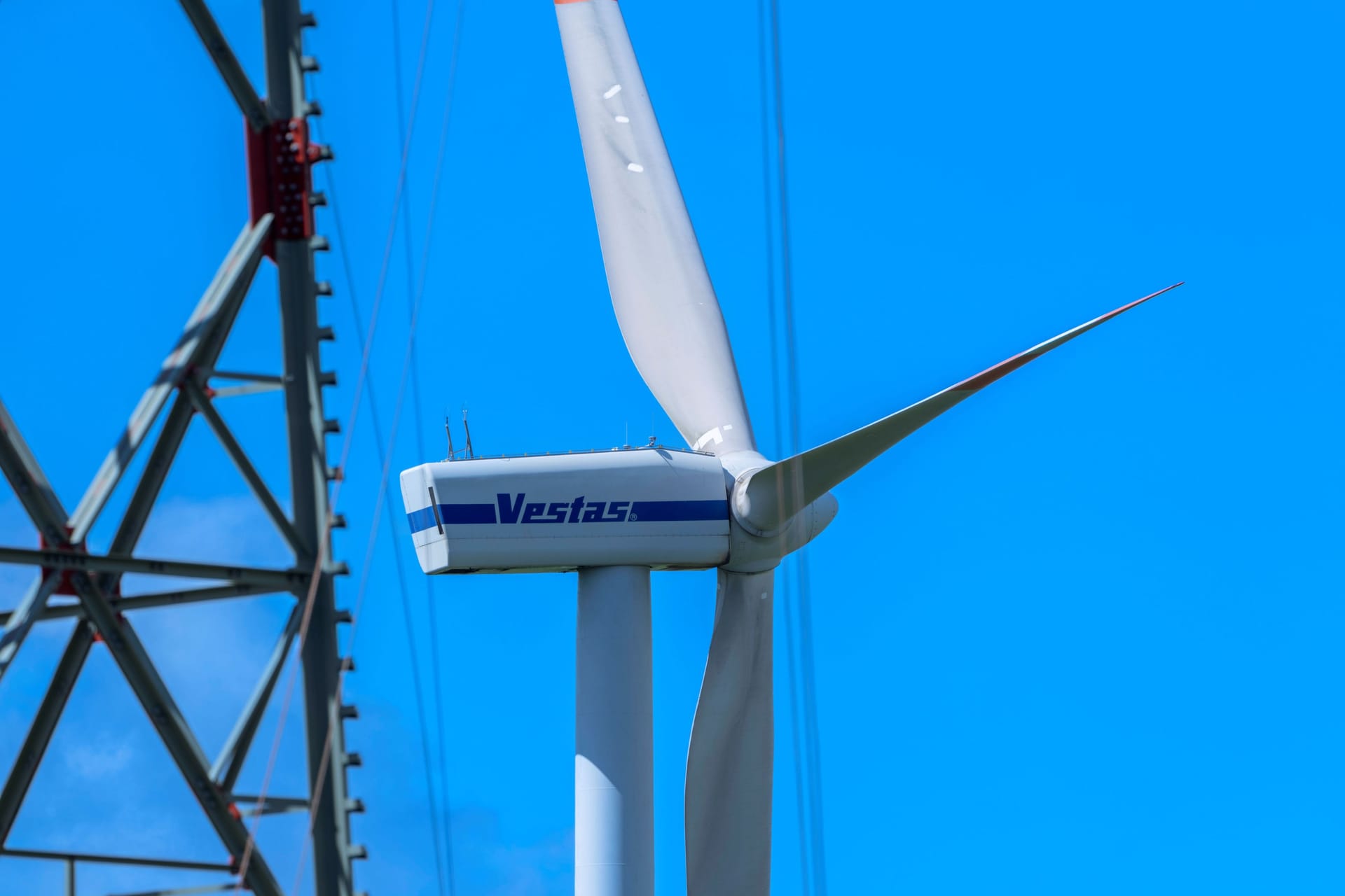 Windrad neben Strommast: Netzengpässe belasten Steuerzahler trotz Fortschritten.