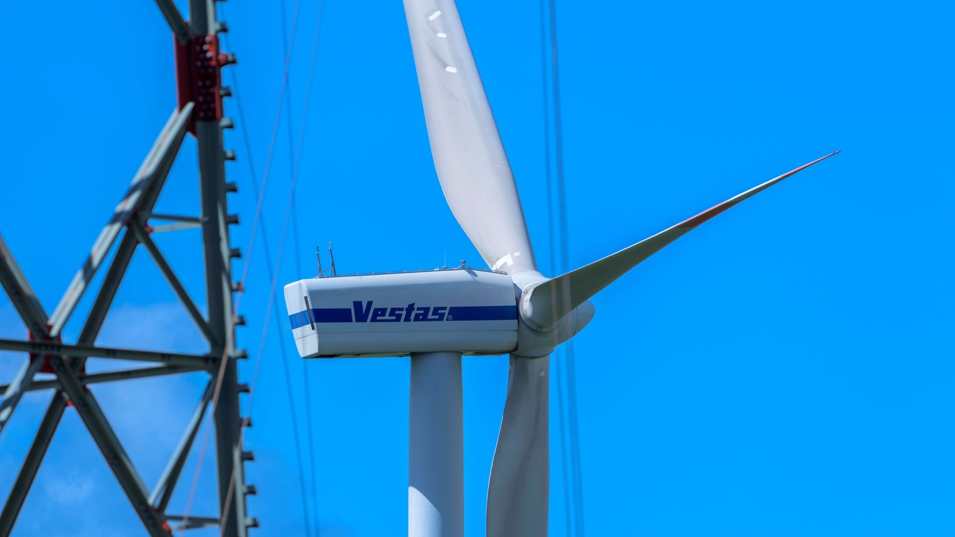 Windrad neben Strommast: Netzengpässe belasten Steuerzahler trotz Fortschritten.