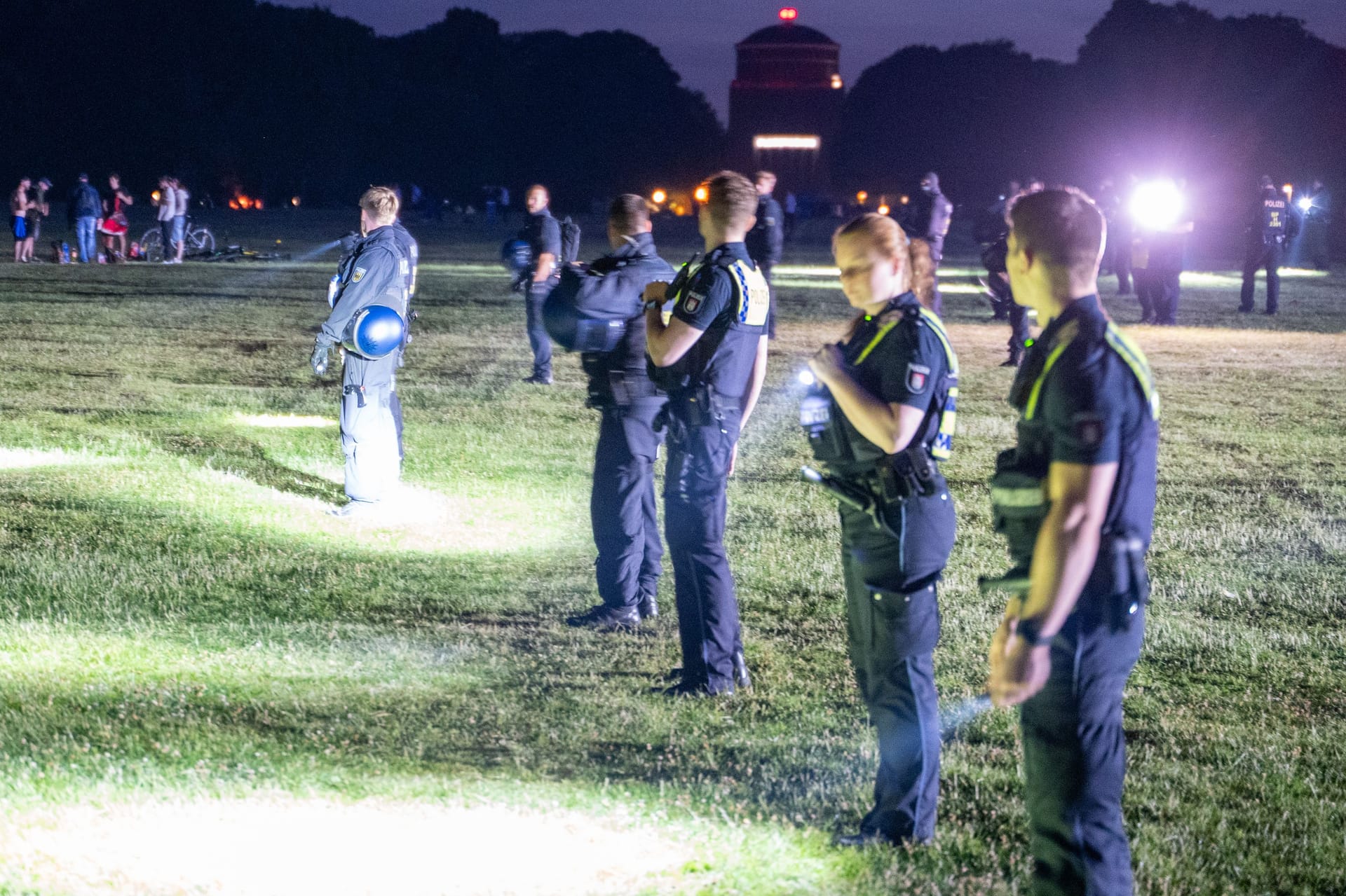 Polizeibeamte suchen ein Messer im Stadtpark: Bei einer eskalierten Schlägerei ist am Samstagabend ein Jugendlicher niedergestochen worden.