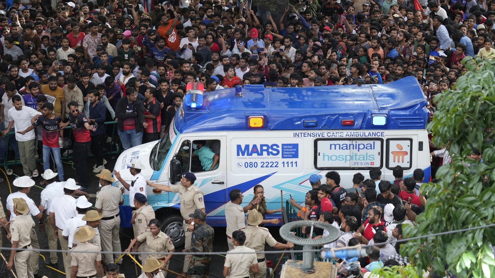 Großeinsatz: Ein Krankenwagen bahnt sich den Weg durch die Menschenmassen in Bengaluru.