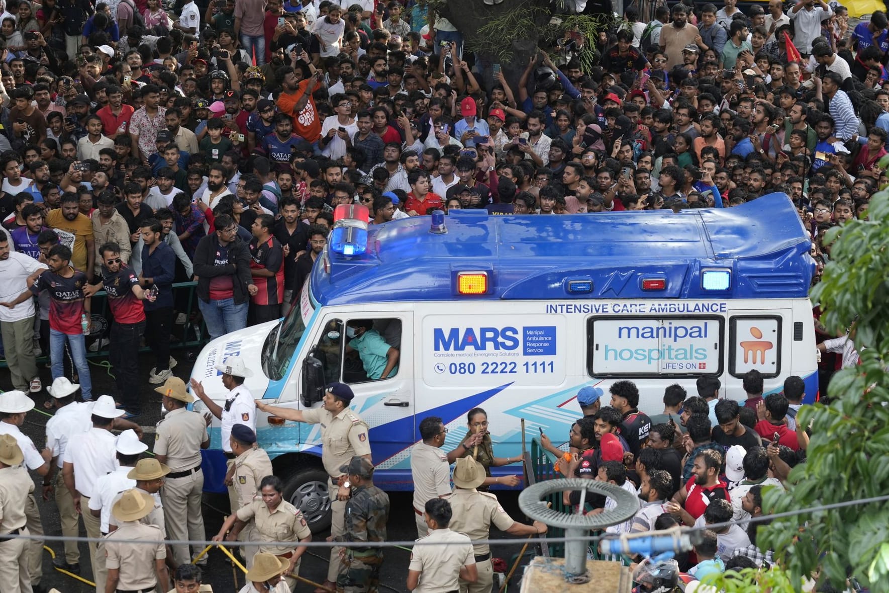 Großeinsatz: Ein Krankenwagen bahnt sich den Weg durch die Menschenmassen in Bengaluru.