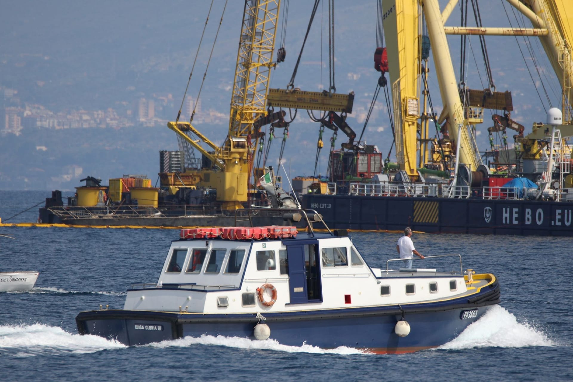 Der Rumpf der Superyacht "Bayesian" wird während der Bergungsarbeiten vor dem Dorf Porticciolo von Kränen angehoben.