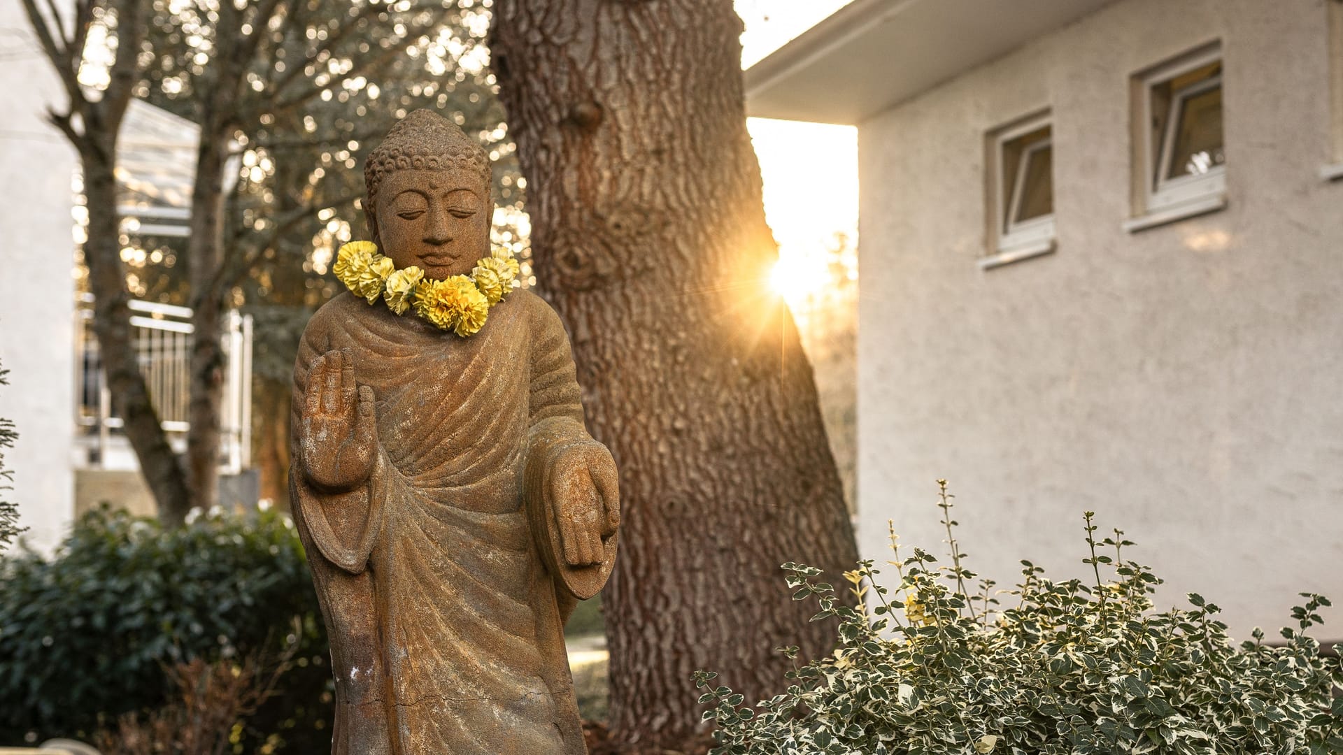 Ruhe tanken im Garten des Kur- und Gesundheitshotels Schiffmann – mit Blick auf die Buddha-Statue im sanften Morgenlicht.