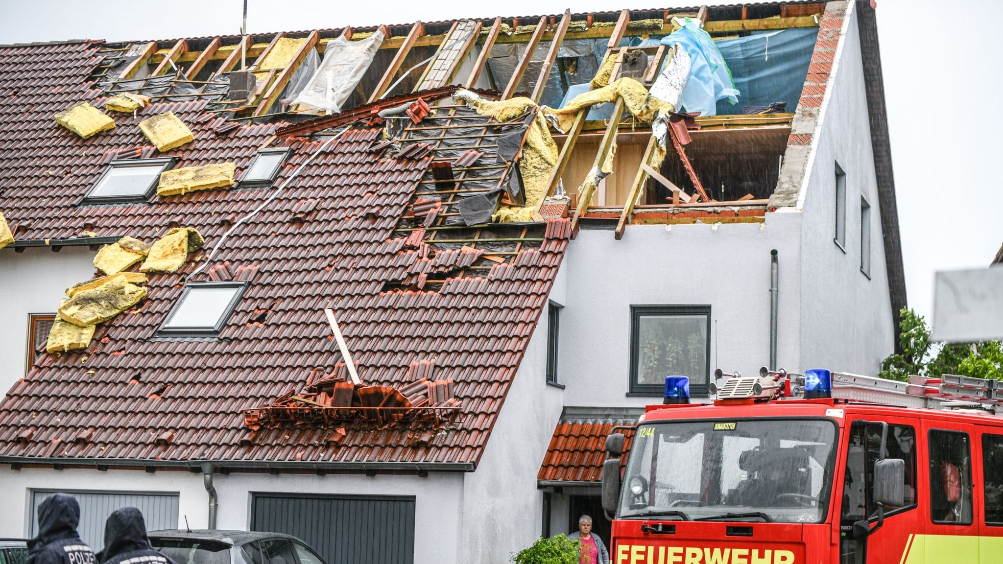 Einsatzkräfte von Feuerwehr und Polizei sind im Stadtteil Donaustetten im Einsatz, nachdem durch das Unwetter das Dach eines Reihenhauses stark beschädigt wurde.