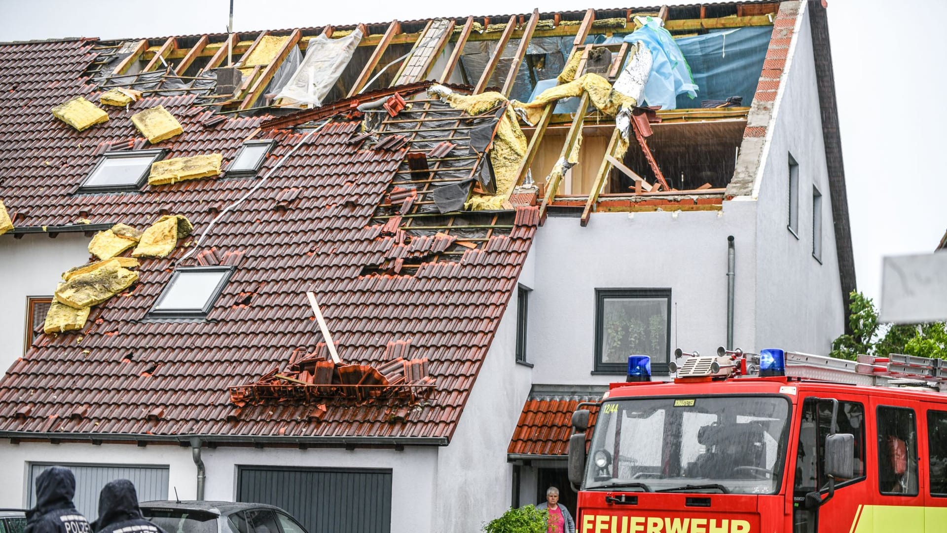 Einsatzkräfte von Feuerwehr und Polizei sind im Stadtteil Donaustetten im Einsatz, nachdem durch das Unwetter das Dach eines Reihenhauses stark beschädigt wurde.