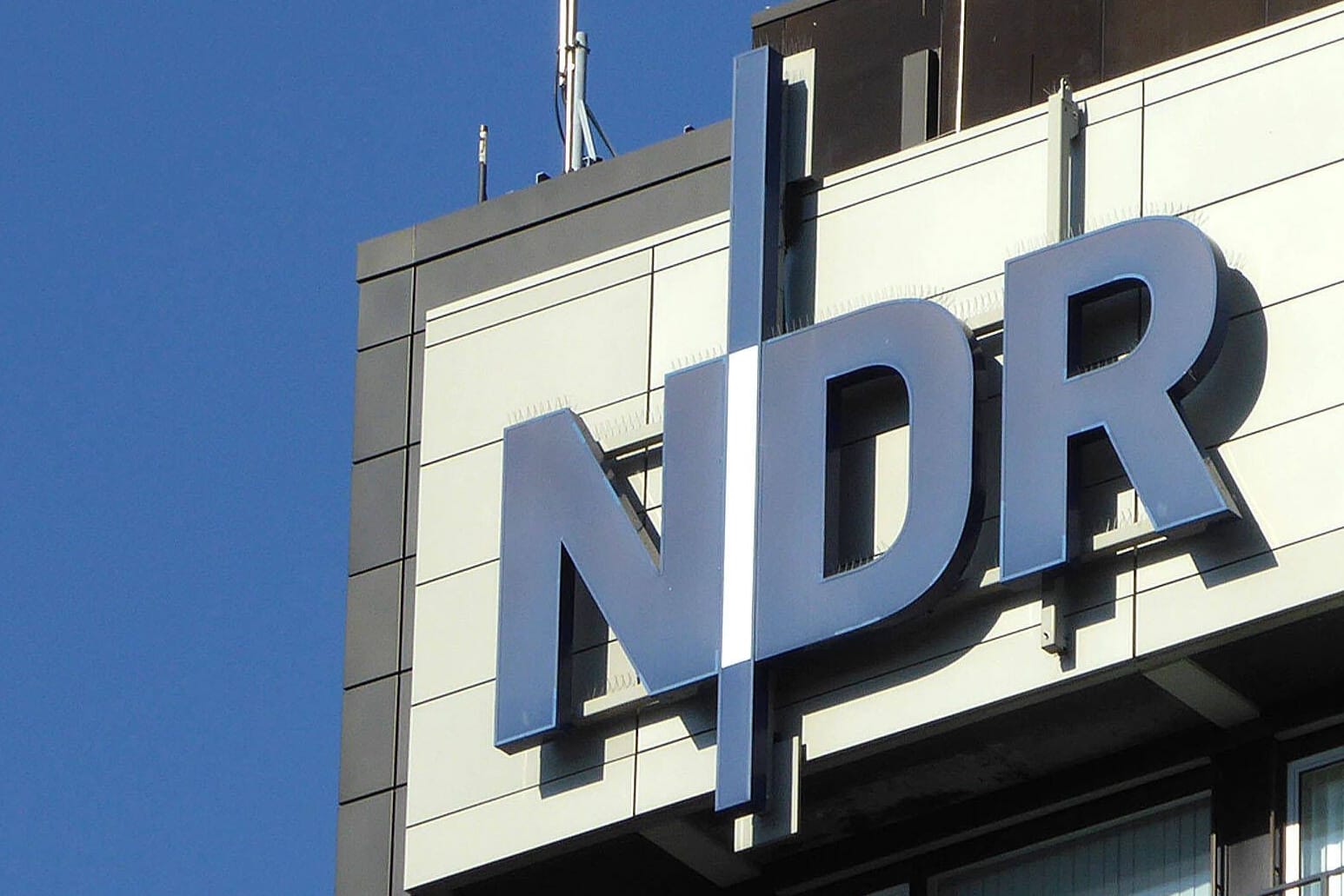 Das Logo des NDR an einem Gebäude (Symbolbild): Bis Ende 2026 fallen drei Radioprogramme der norddeutschen Rundfunkanstalt ersatzlos weg.