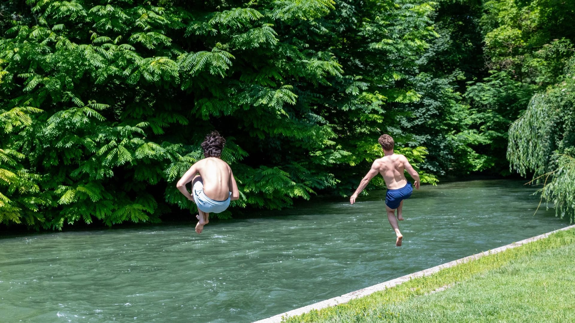 Zwei Kinder springen in einen Fluss (Symbolbild): Während der kommenden Hitzewelle drohen Deutschland Temperaturen von 40 Grad.