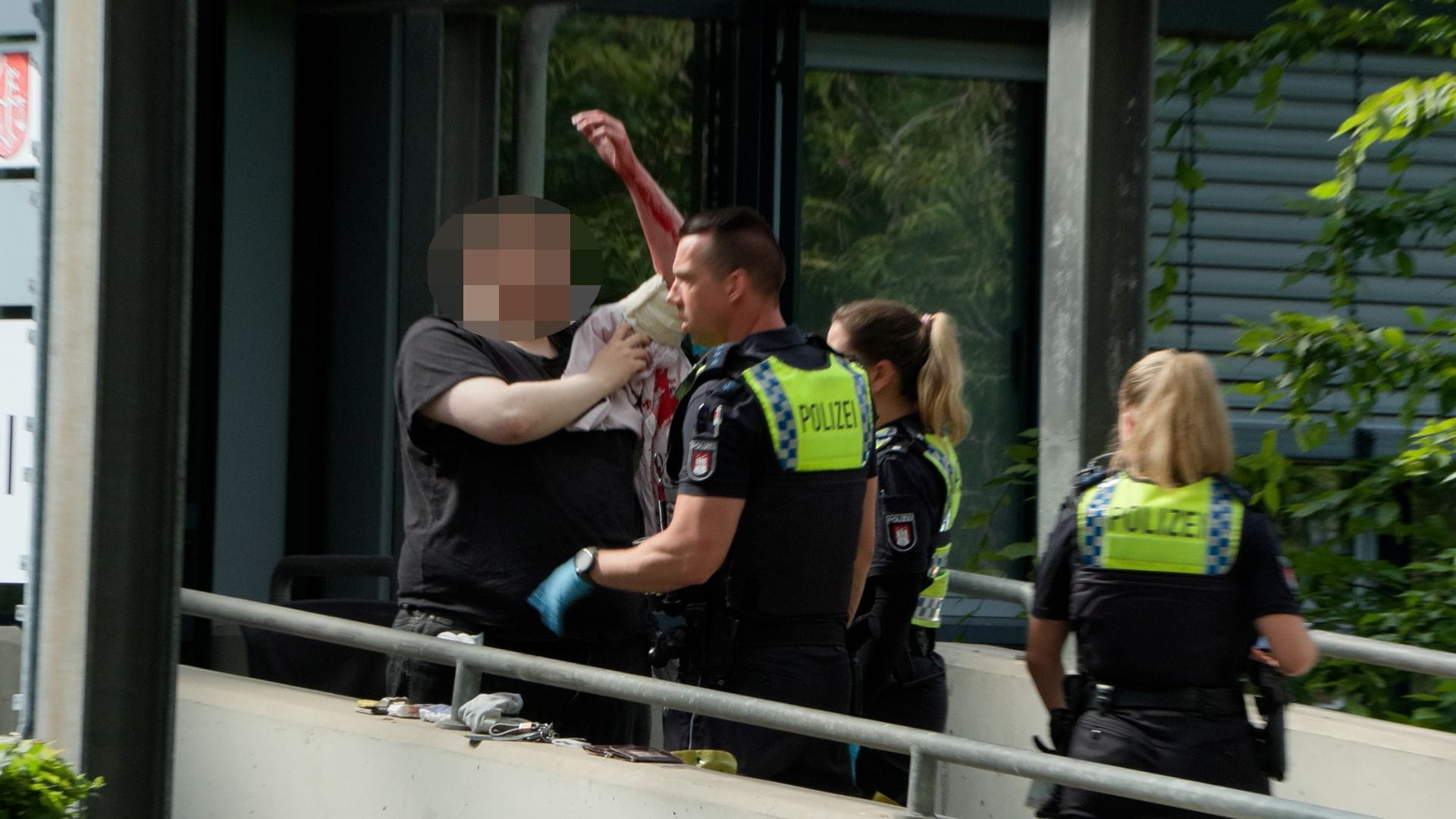 Polizeibeamte kümmern sich um einen blutenden Mann: Bei einem Messerstreit in Hamburg-Harburg wurden zwei Menschen verletzt, eine Frau schwer.