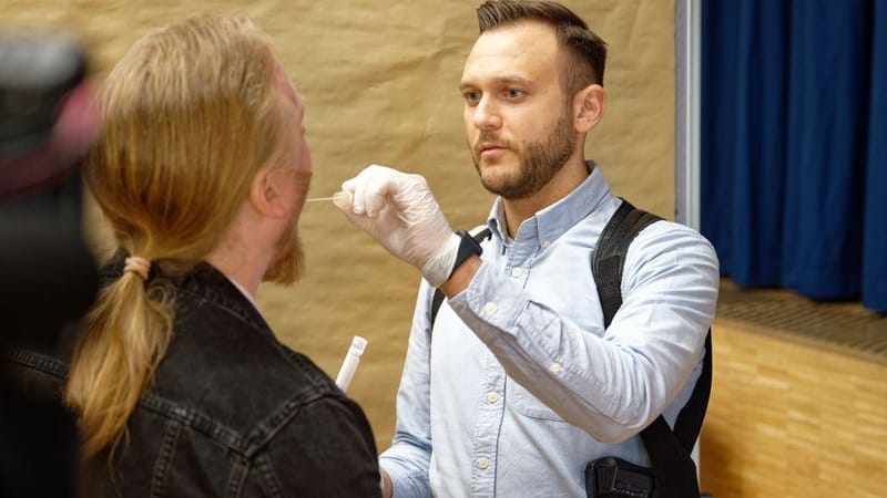 Ein Polizeibeamter demonstriert in einer gestellten Szene die Abnahme einer DNA-Probe (Symbolbild): Ein Massengentest konnte den Ermittlern in einem Cold Case nicht weiterhelfen.