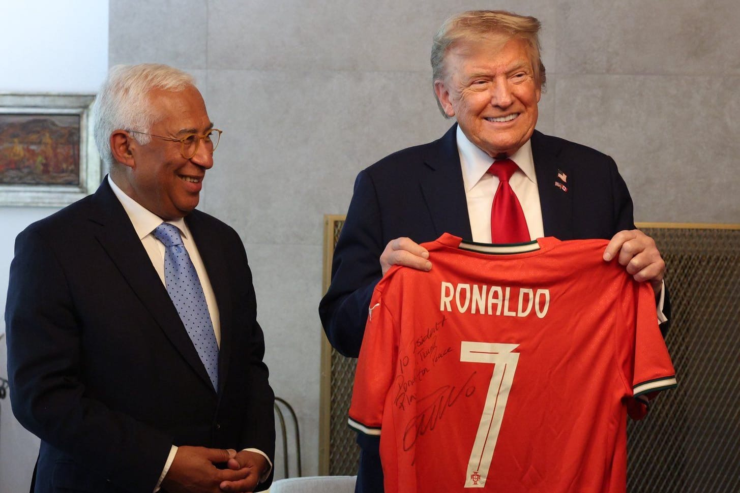 Donald Trump (r.) hält ein signiertes Trikot von Cristiano Ronaldo in den Händen. Neben ihm steht der portugiesische EU-Ratspräsident António Costa.