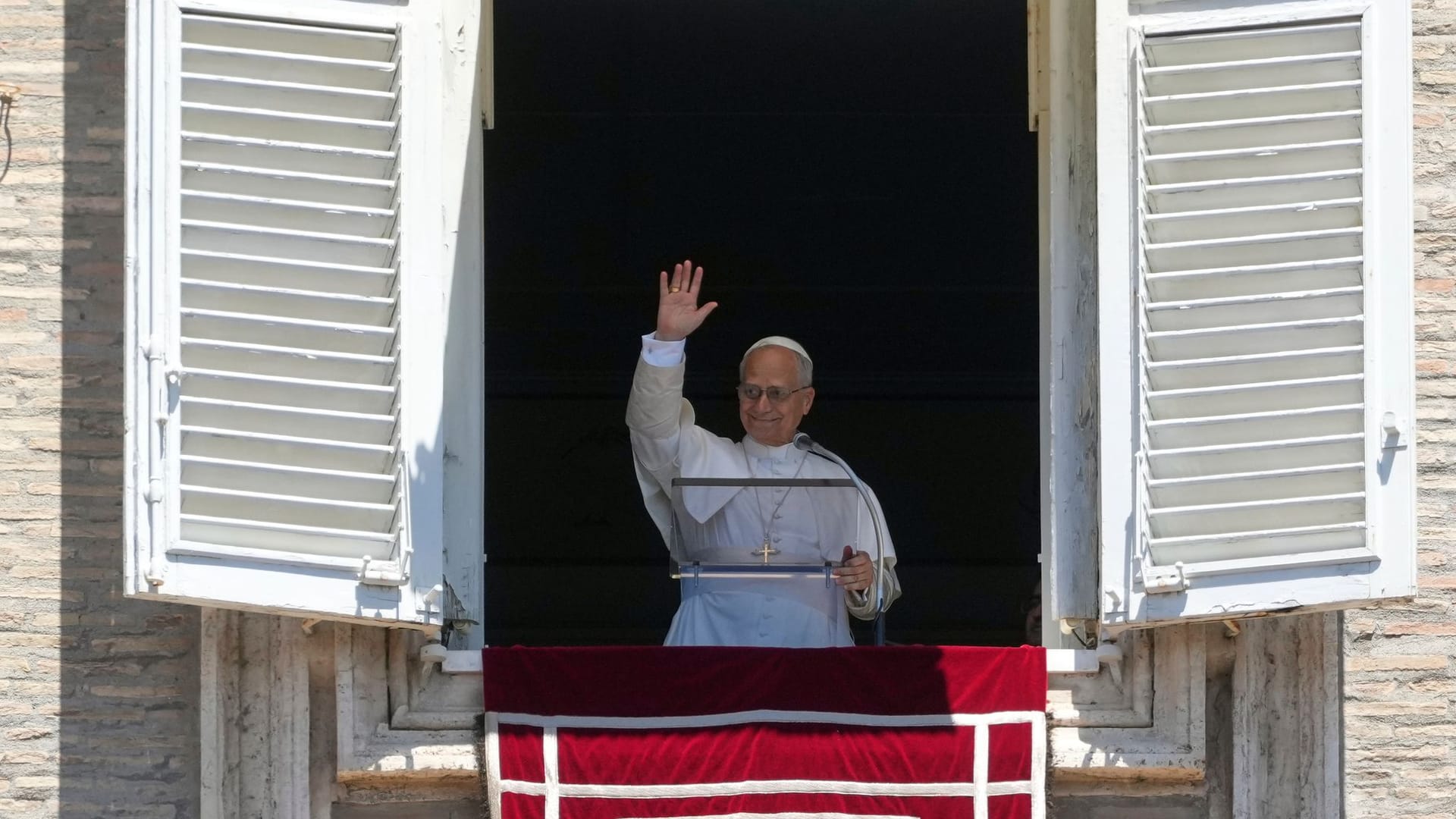 Papst Leo XIV. steht am Fenster, um die auf dem Petersplatz im Vatikan versammelten Gläubigen zu segnen. Er erneuert Traditionen der katholischen Kirche.