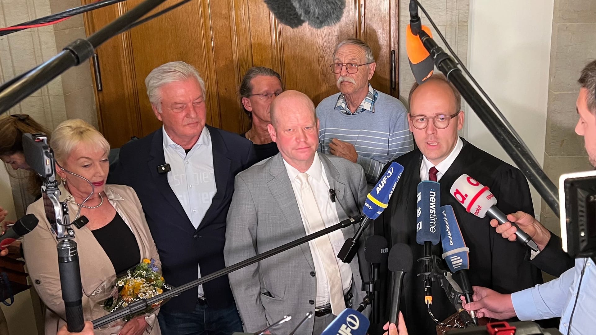 Mit Hemd und Jackett: Jürgen Elsässer mit seiner Frau und den Anwälten in der Verkündung und unmittelbat danach.